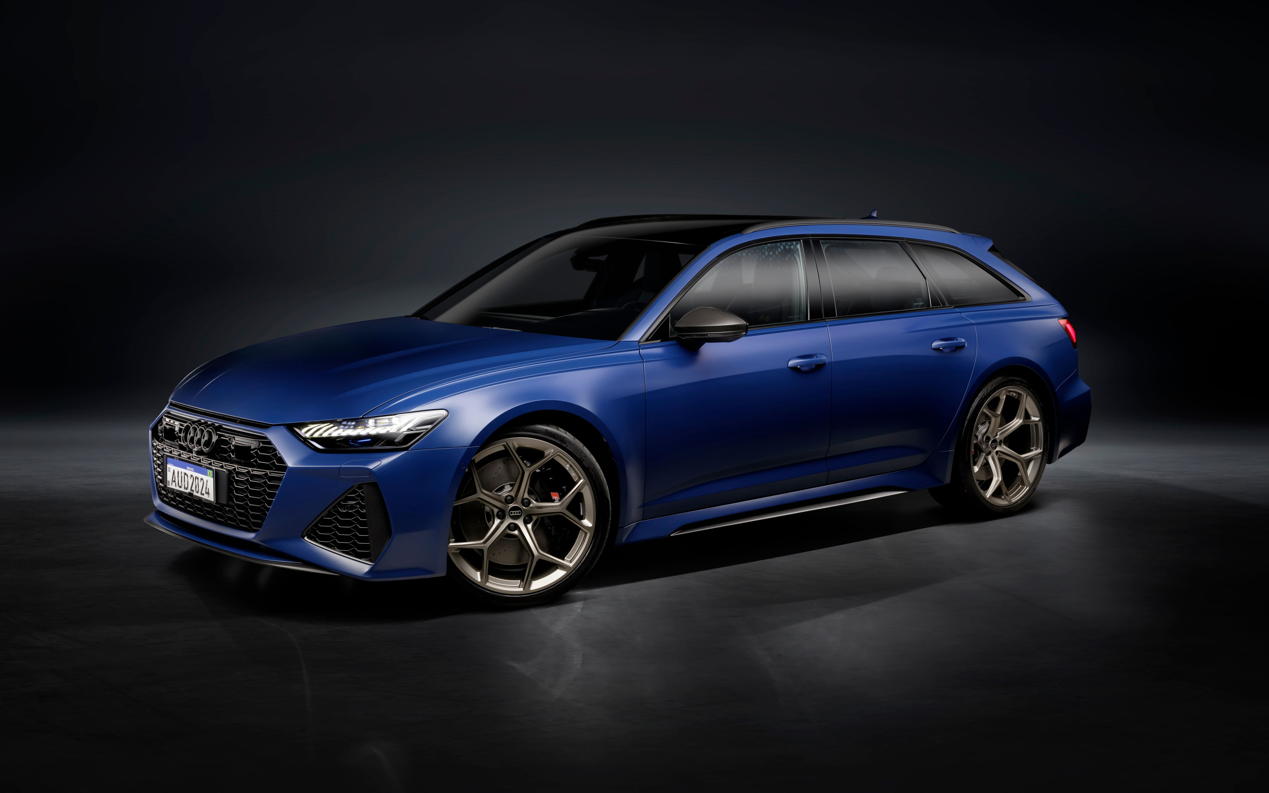 Синий автомобиль Audi RS 6 Avant Legacy 2024 года на сером фоне