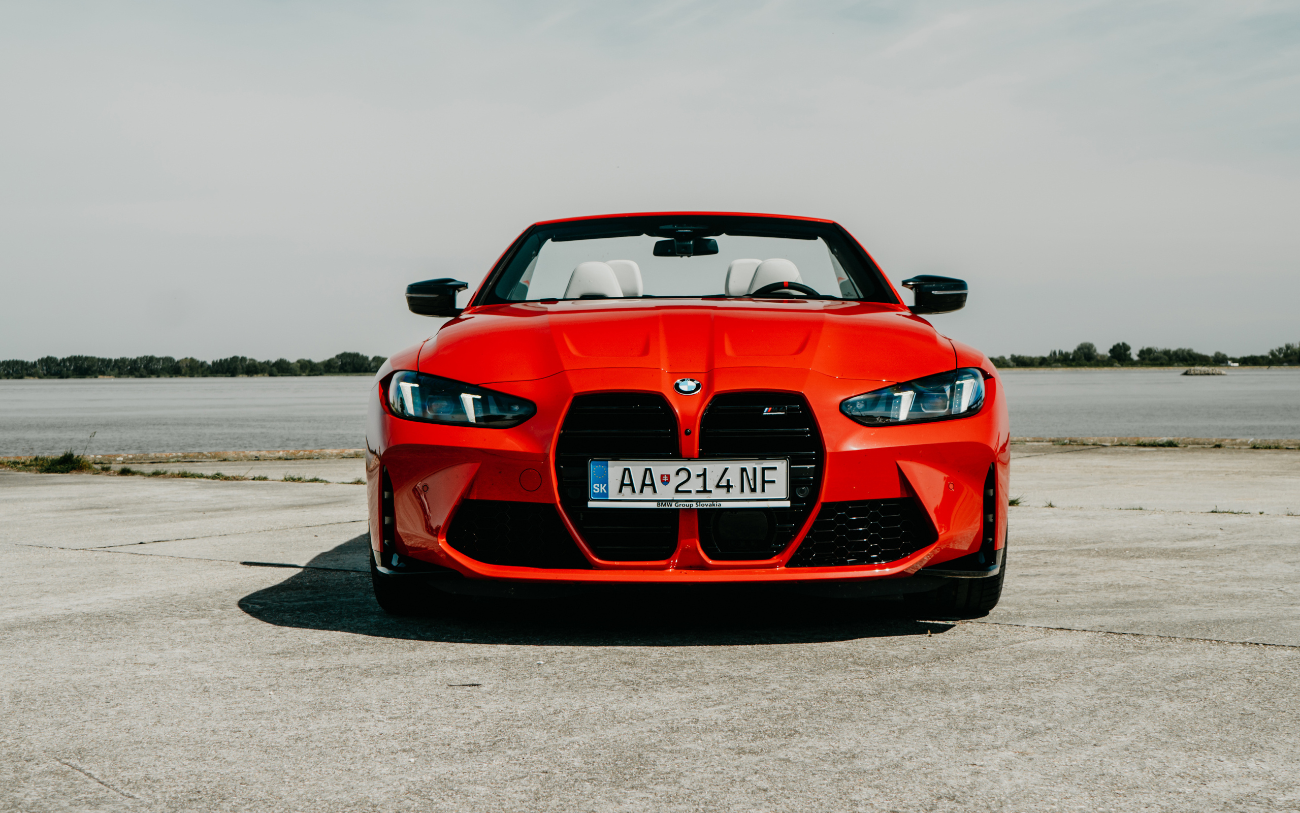 Вид спереди на красный автомобиль BMW M4 Competition M xDrive Cabrio 2024 года