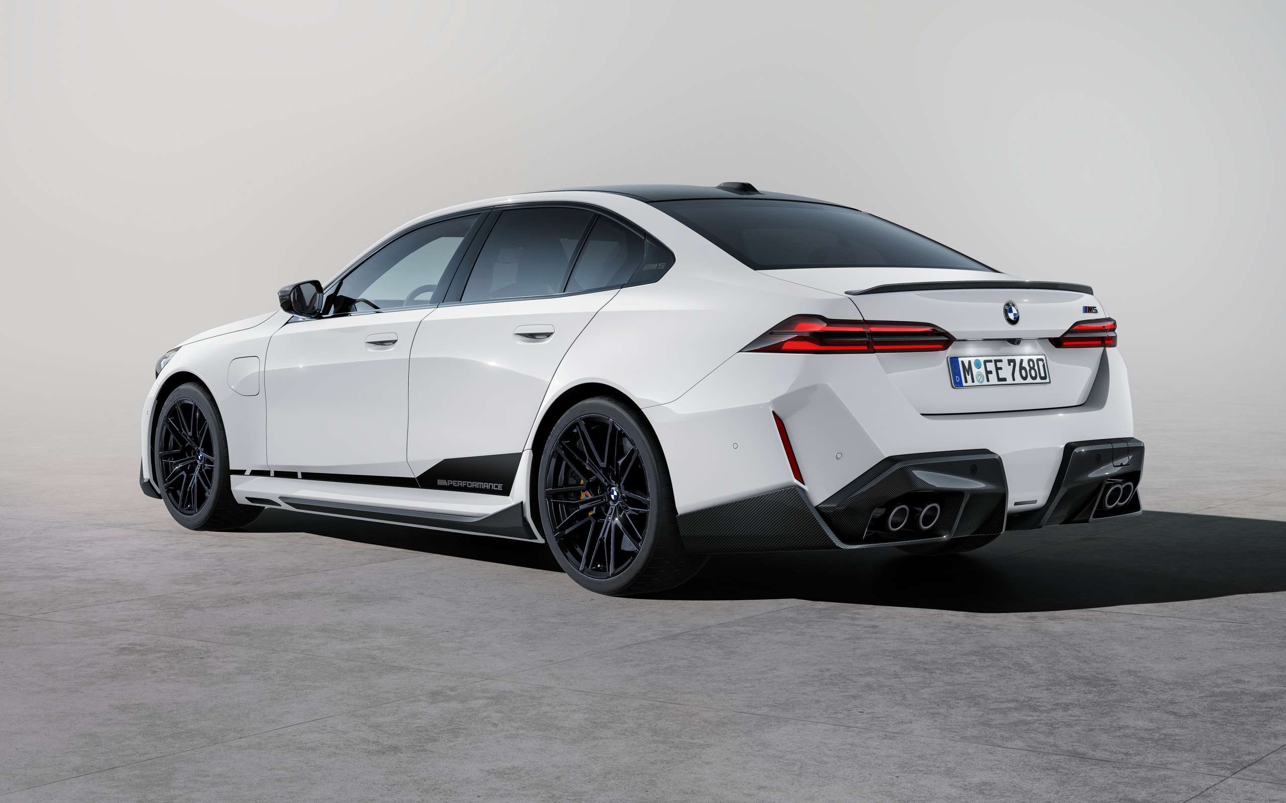 Вид сзади на белый автомобиль BMW M5 M