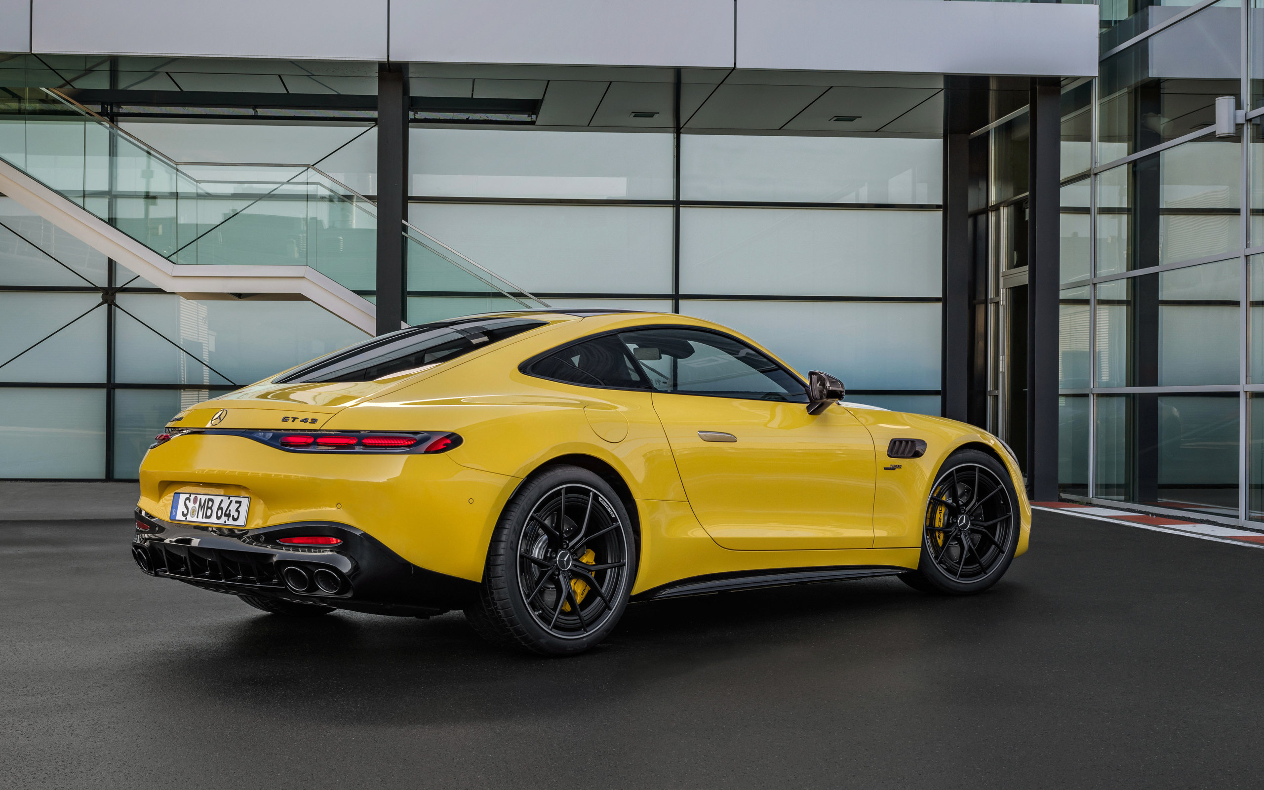 Вид сзади на желтый автомобиль Mercedes-AMG GT 43 Coupe 2024 года