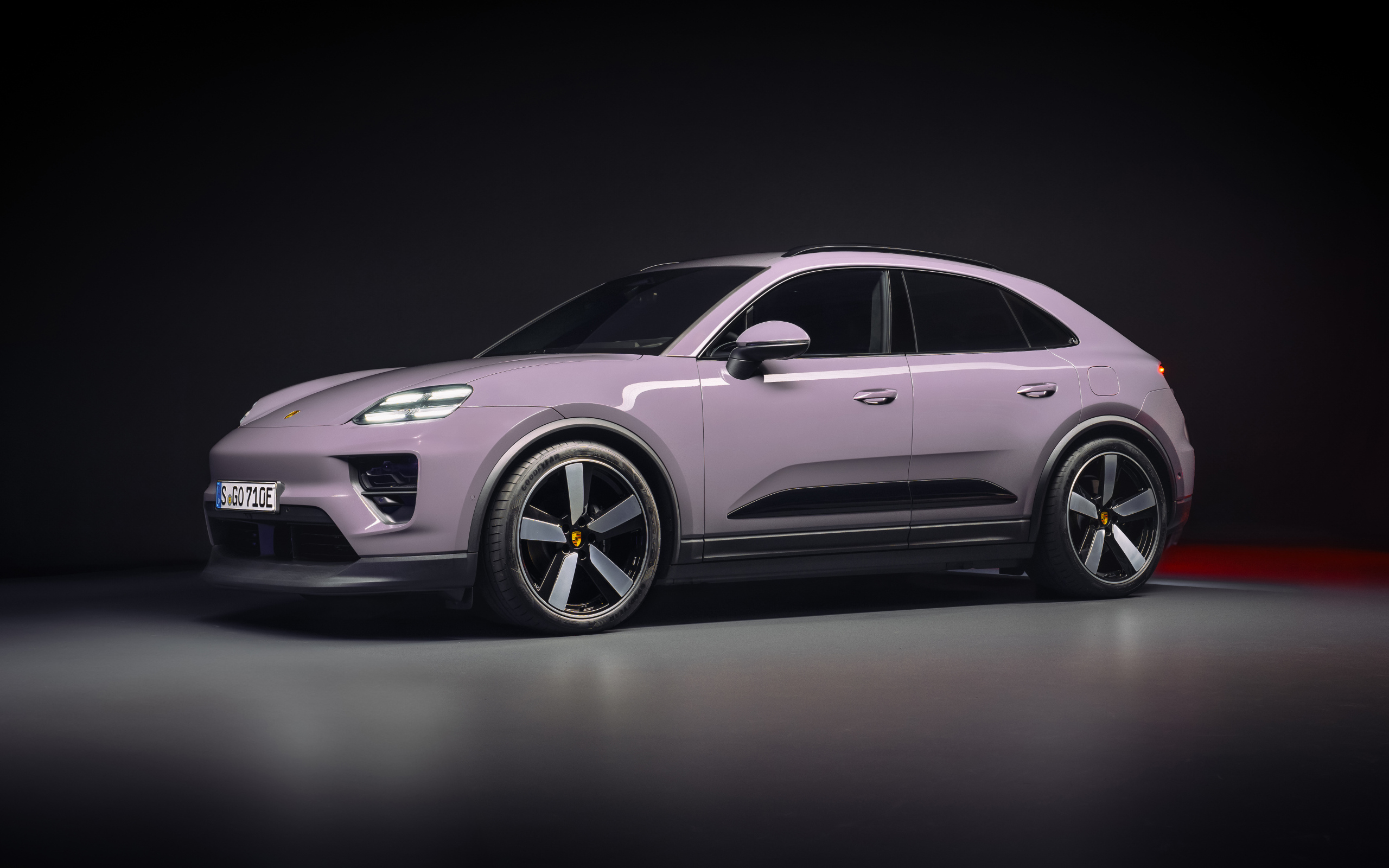Автомобиль Porsche Macan 4 2024 года на черном фоне