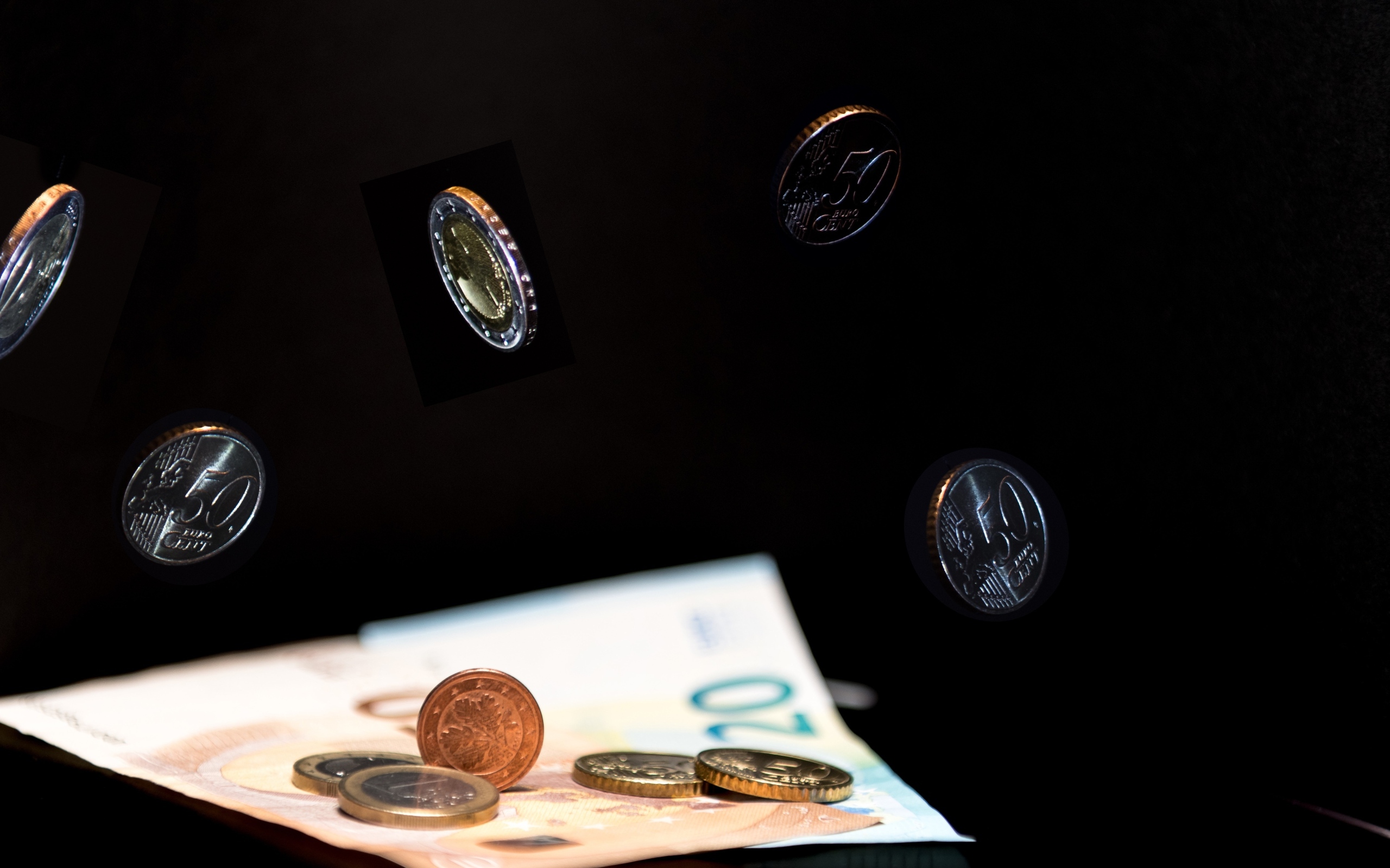 Купюры с монетами на черном фоне