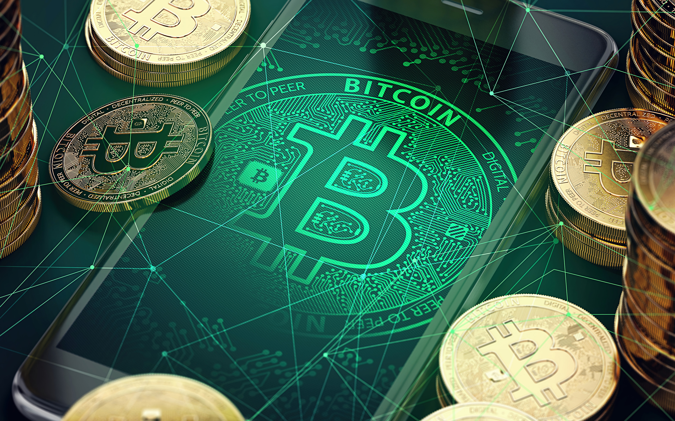 Золотые монеты биткоин со смартфоном на столе