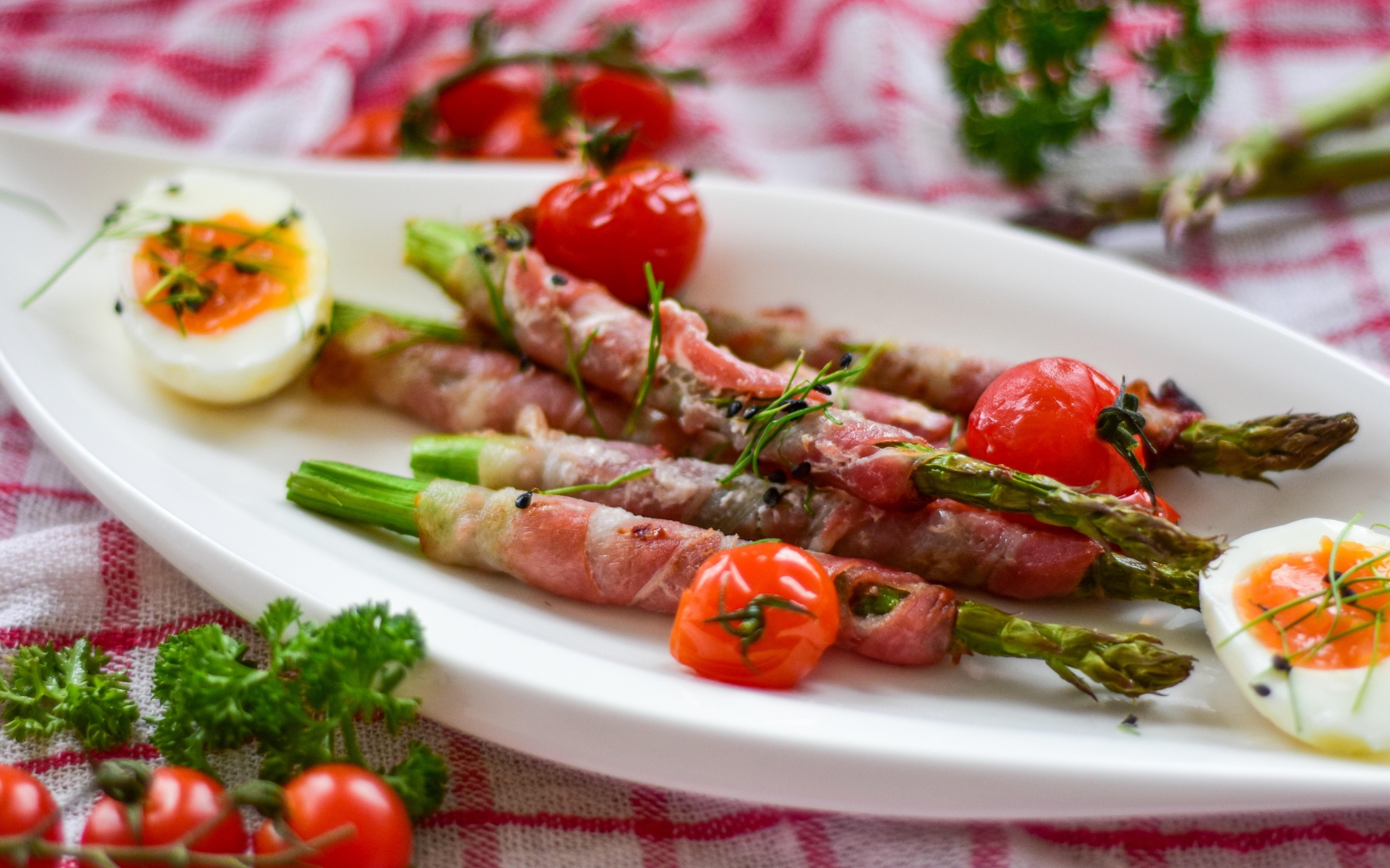 Спаржа в беконе на тарелке с вареными яйцами