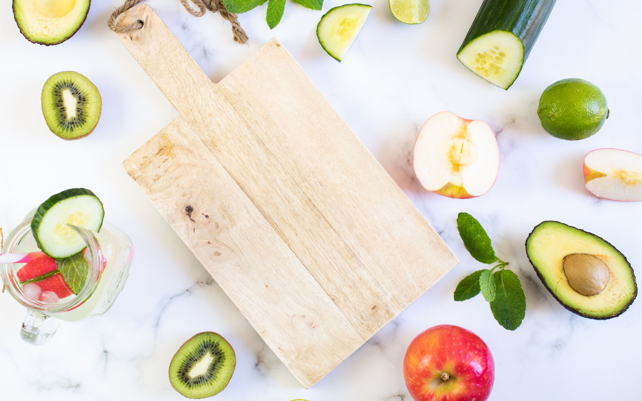 Разделочная доска с фруктами и овощами на столе