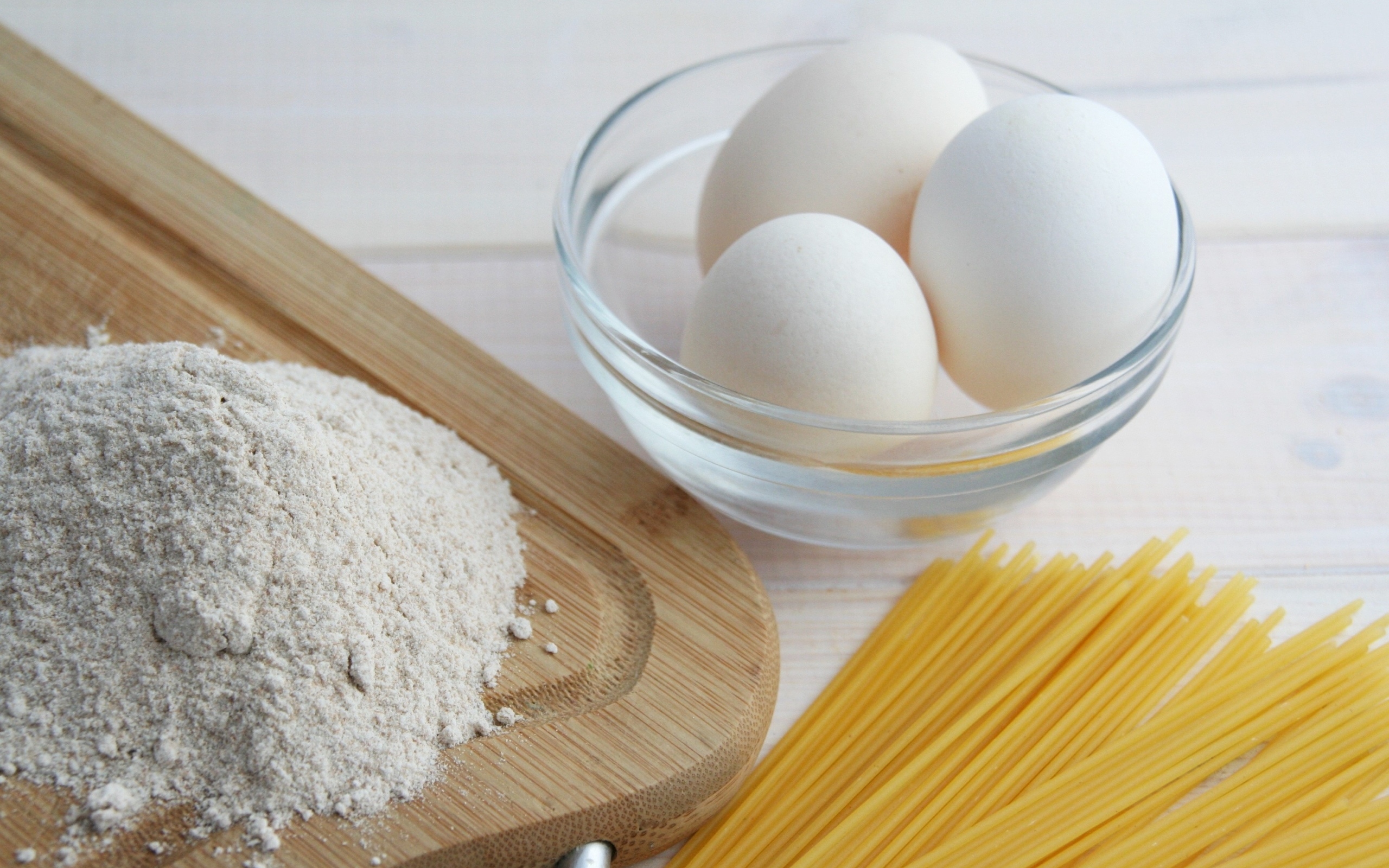 Яйца на столе с мукой и спагетти