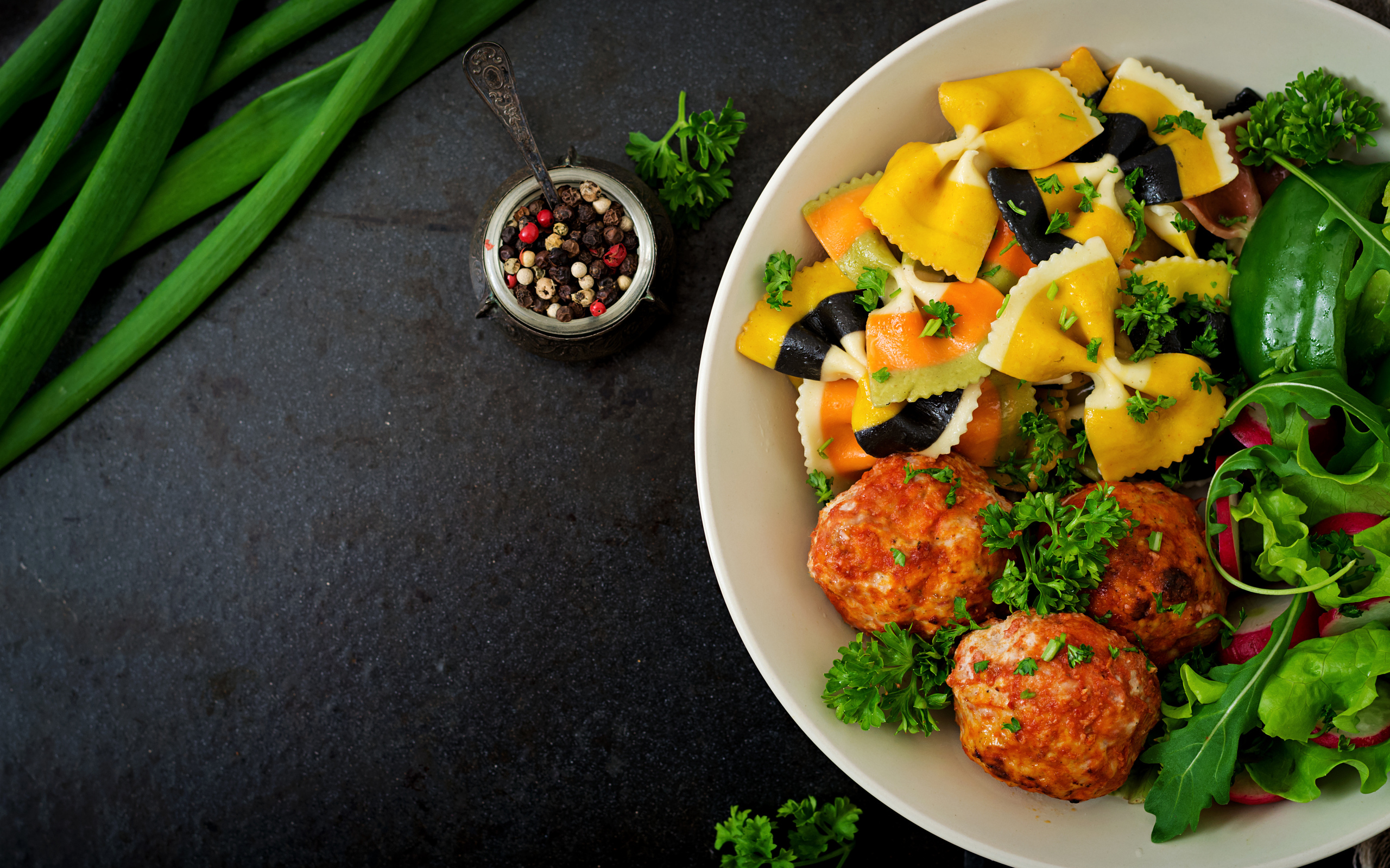 Паста с тефтелями и салатом в тарелке