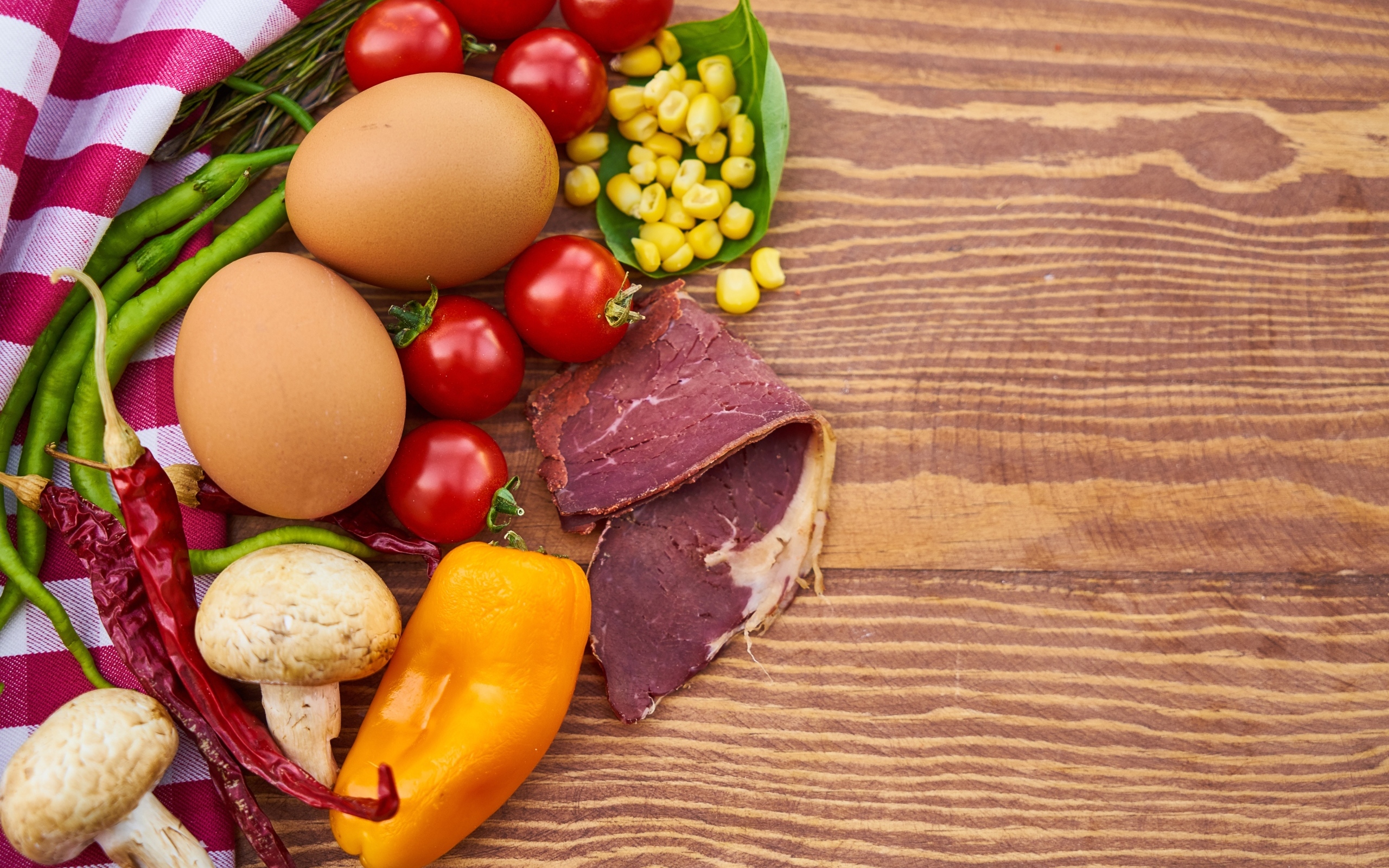 Продукты на деревянном столе с полотенцем