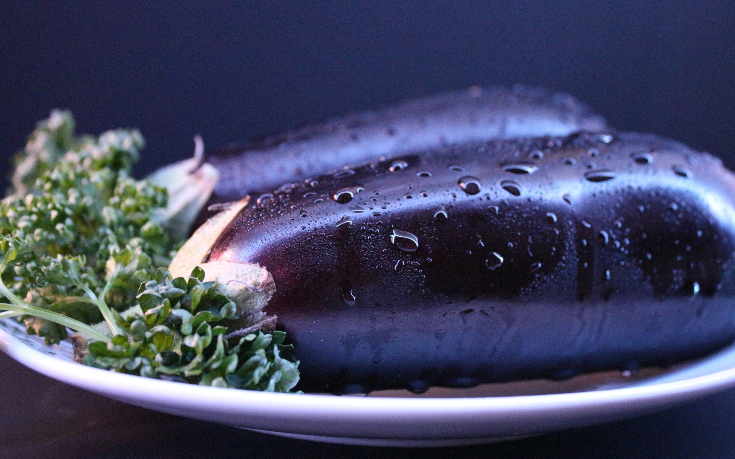 Два баклажана на тарелке с зеленью