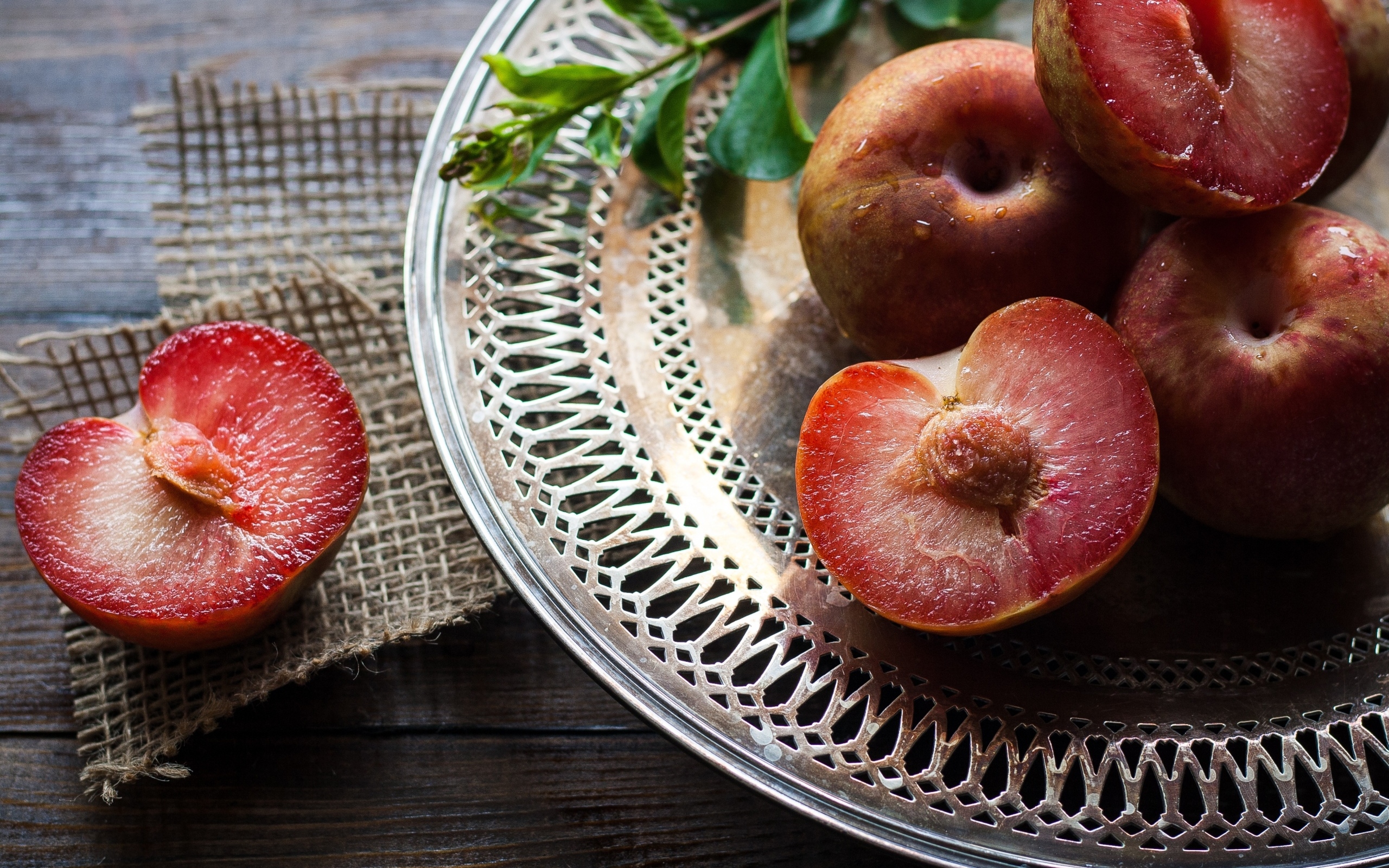 Сочные сливы на тарелке на столе