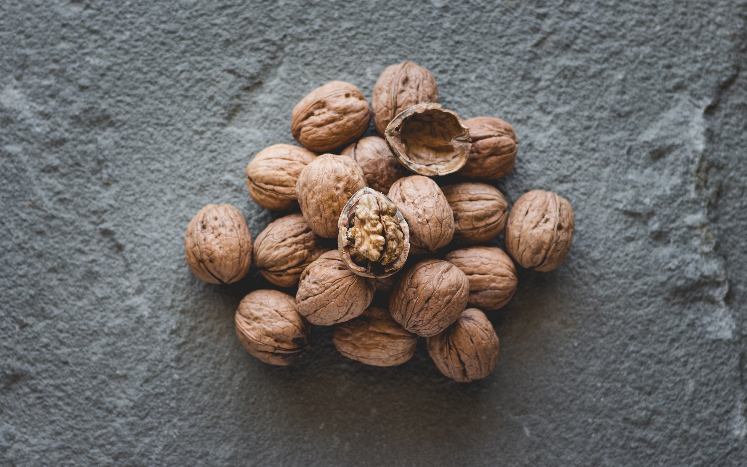 Куча грецких орехов на сером столе