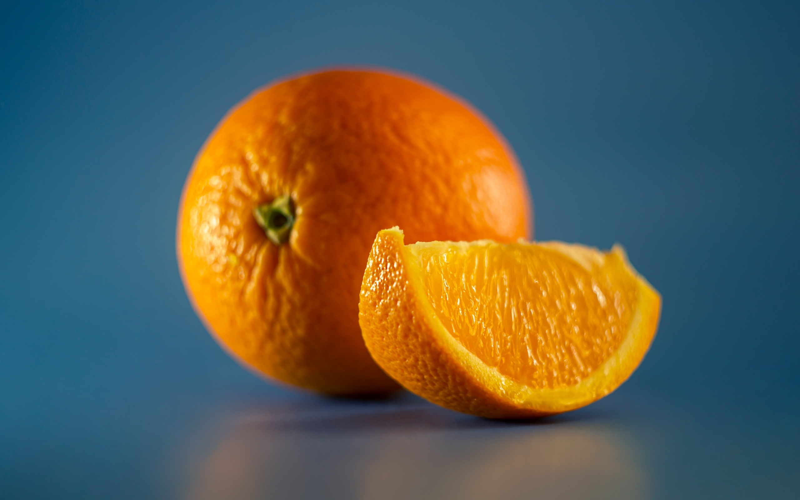Спелый оранжевый апельсин на голубом фоне