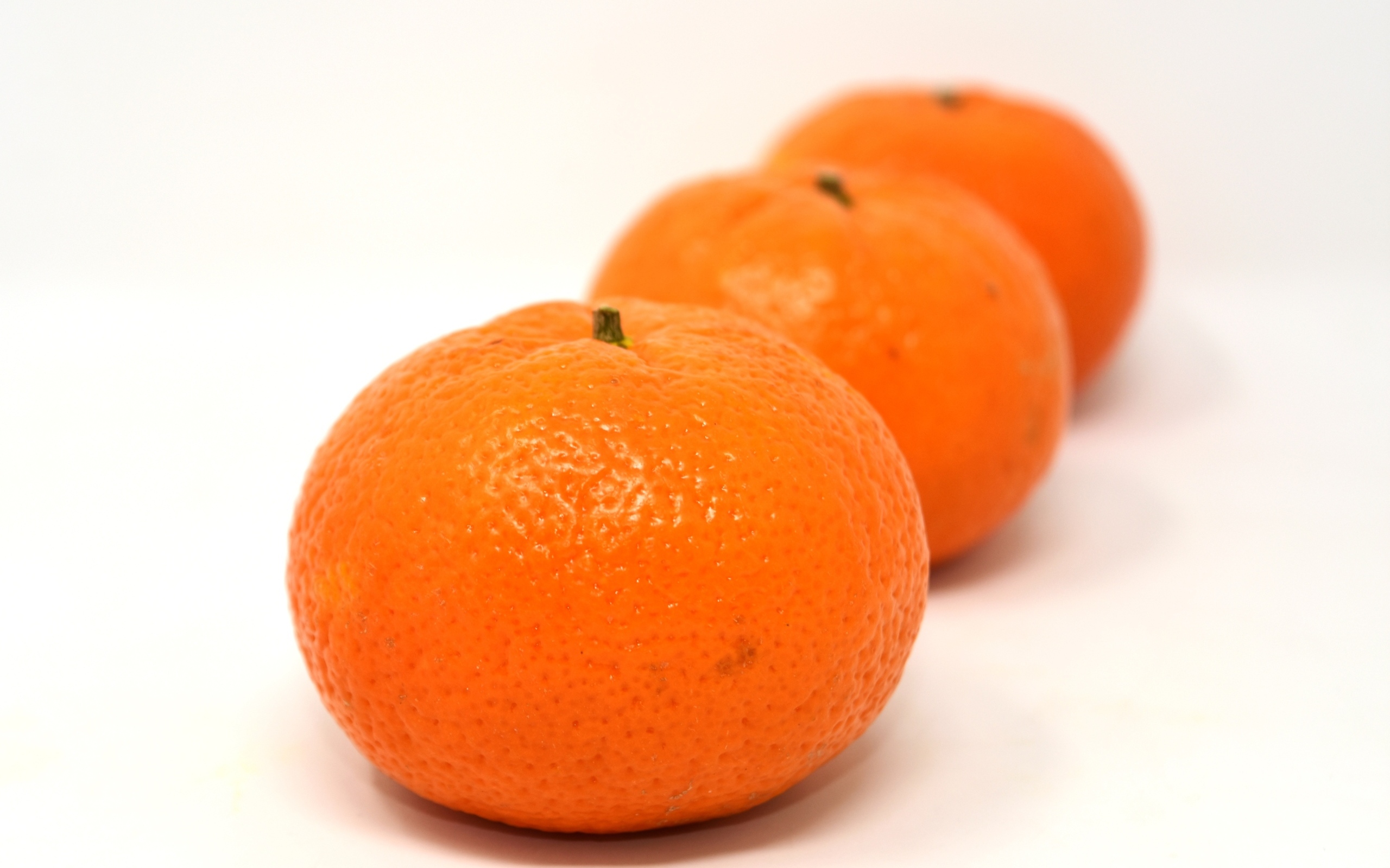 Три больших спелых мандарина на столе