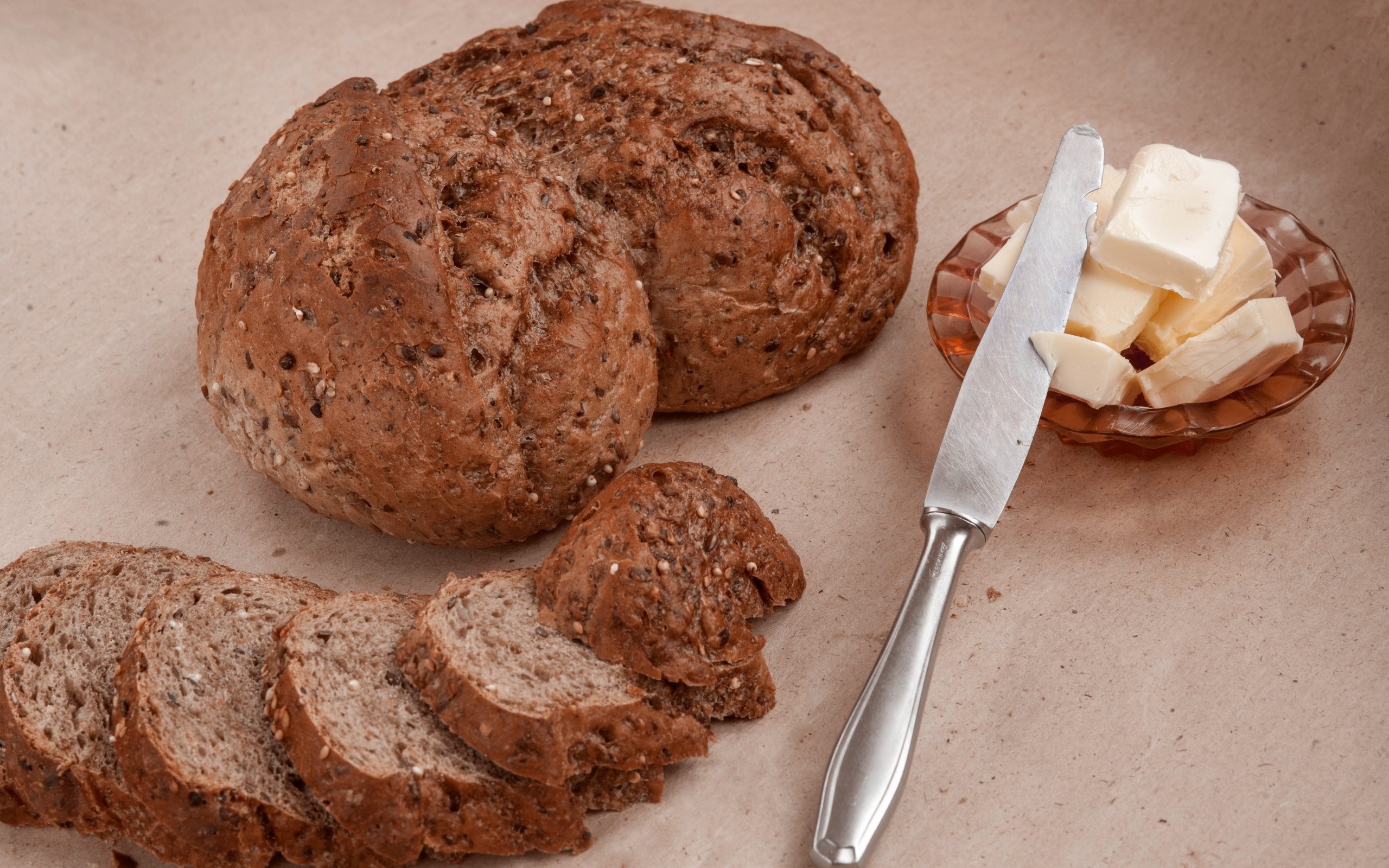 Ржаной хлеб со сливочным маслом и ножом на столе