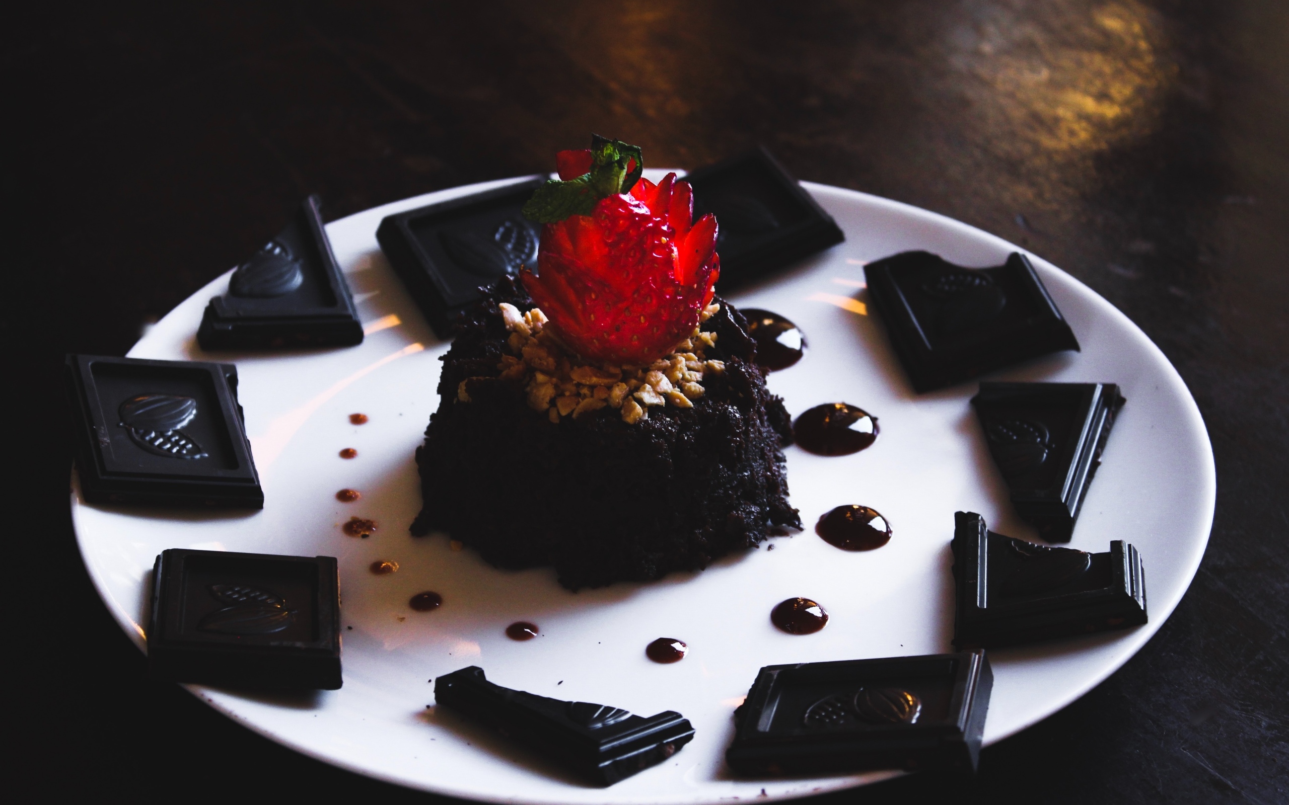 Десерт брауни на большой белой тарелке с шоколадом