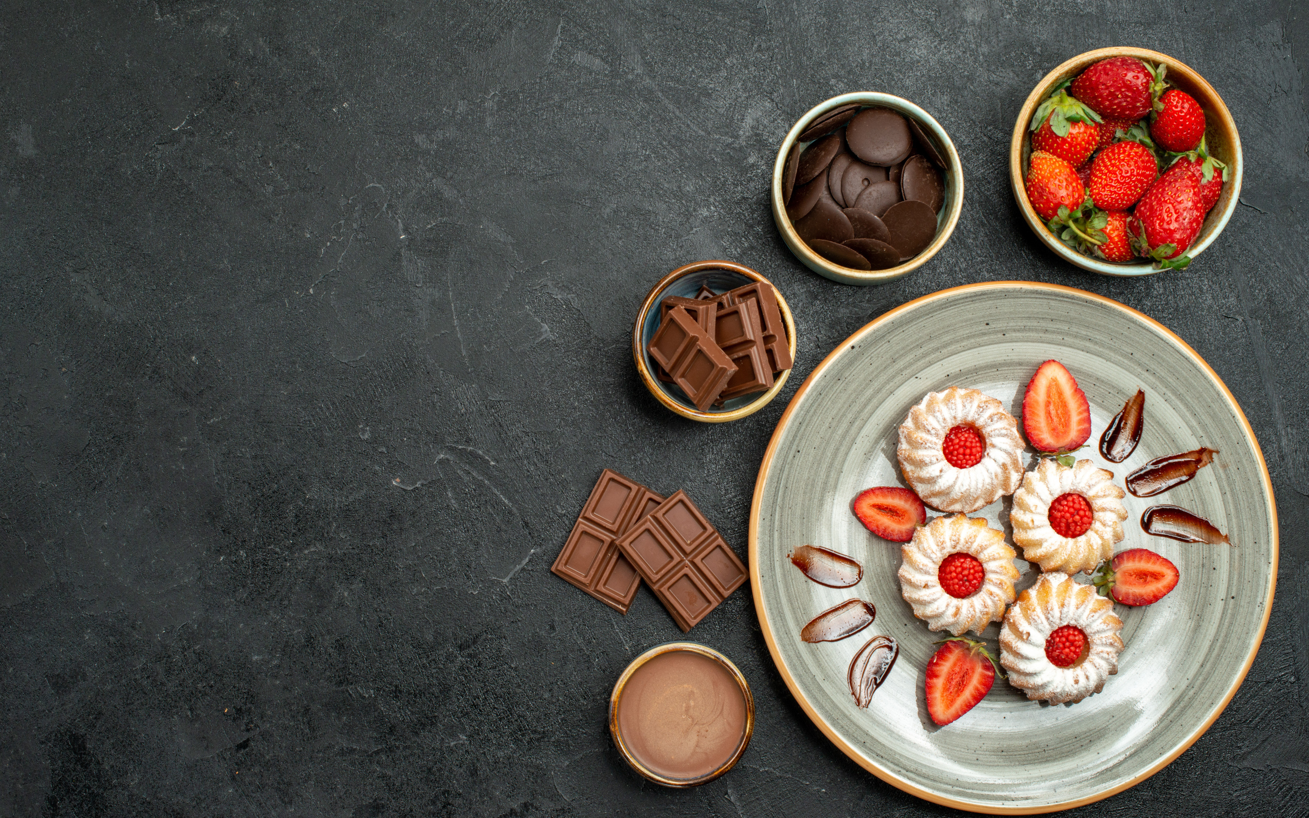 Печенье на столе с шоколадом и ягодами клубники