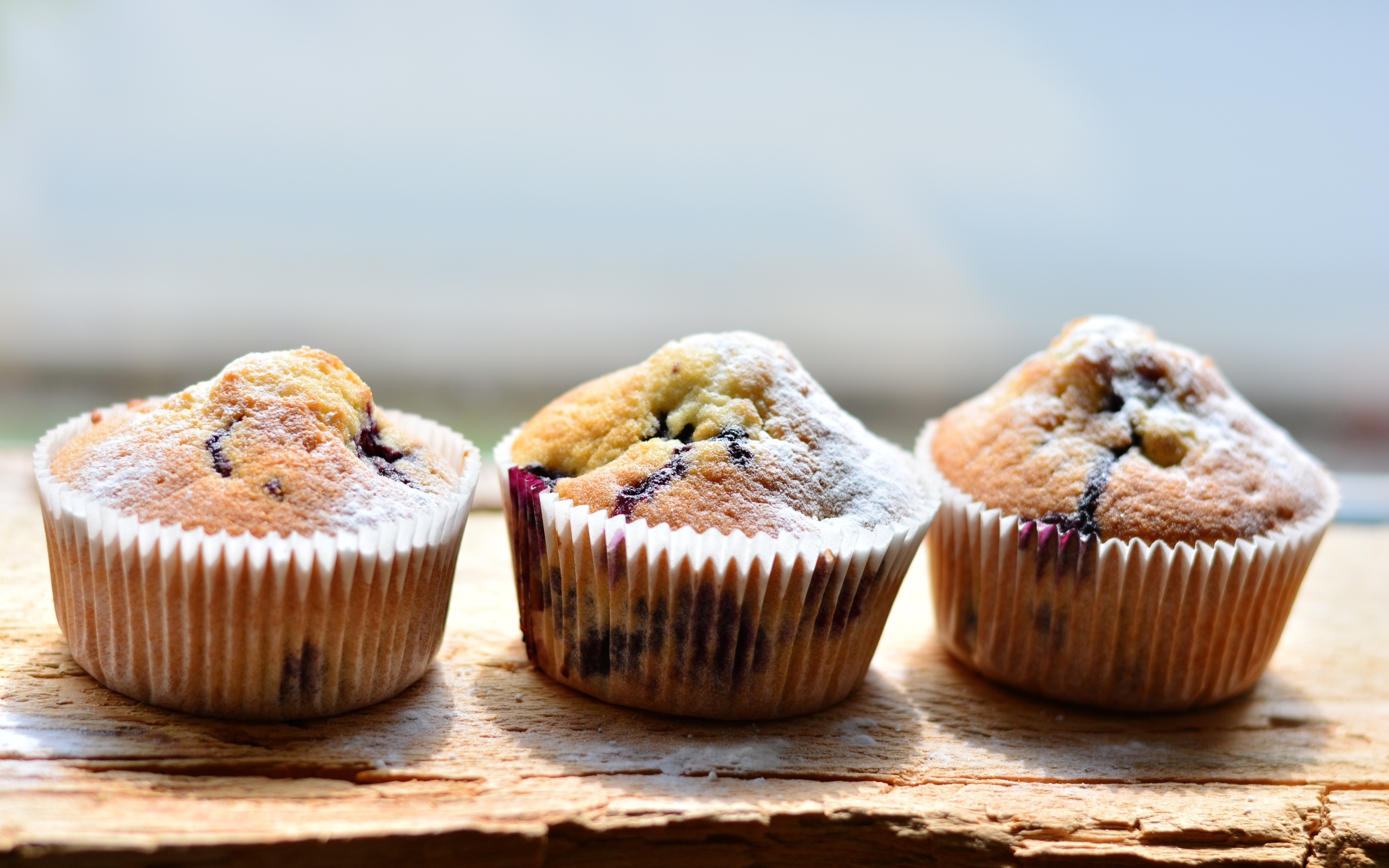 Три вкусных сладких кекса с сахарной пудрой на столе