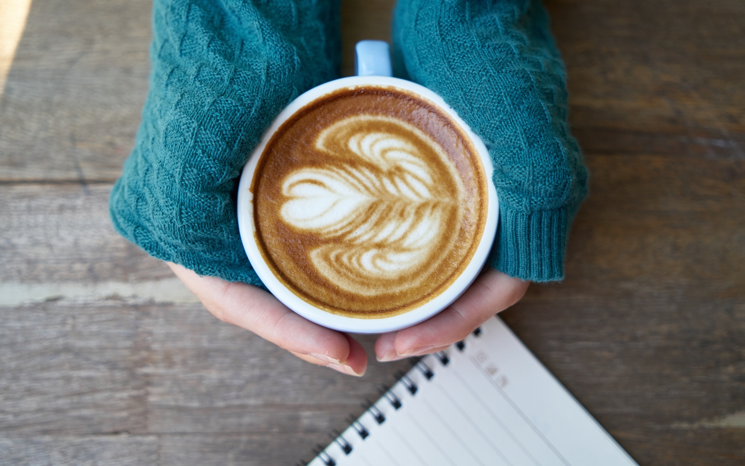 Горячая чашка кофе на столе в руках девушки