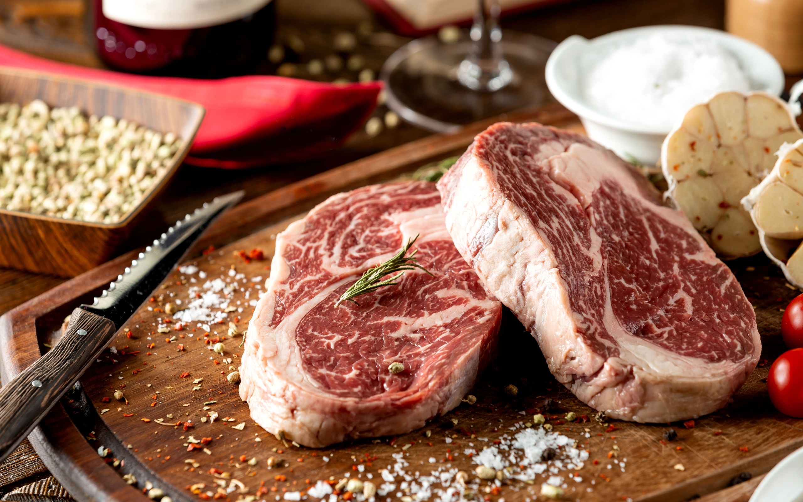 Два куска аппетитного стейка на столе со специями