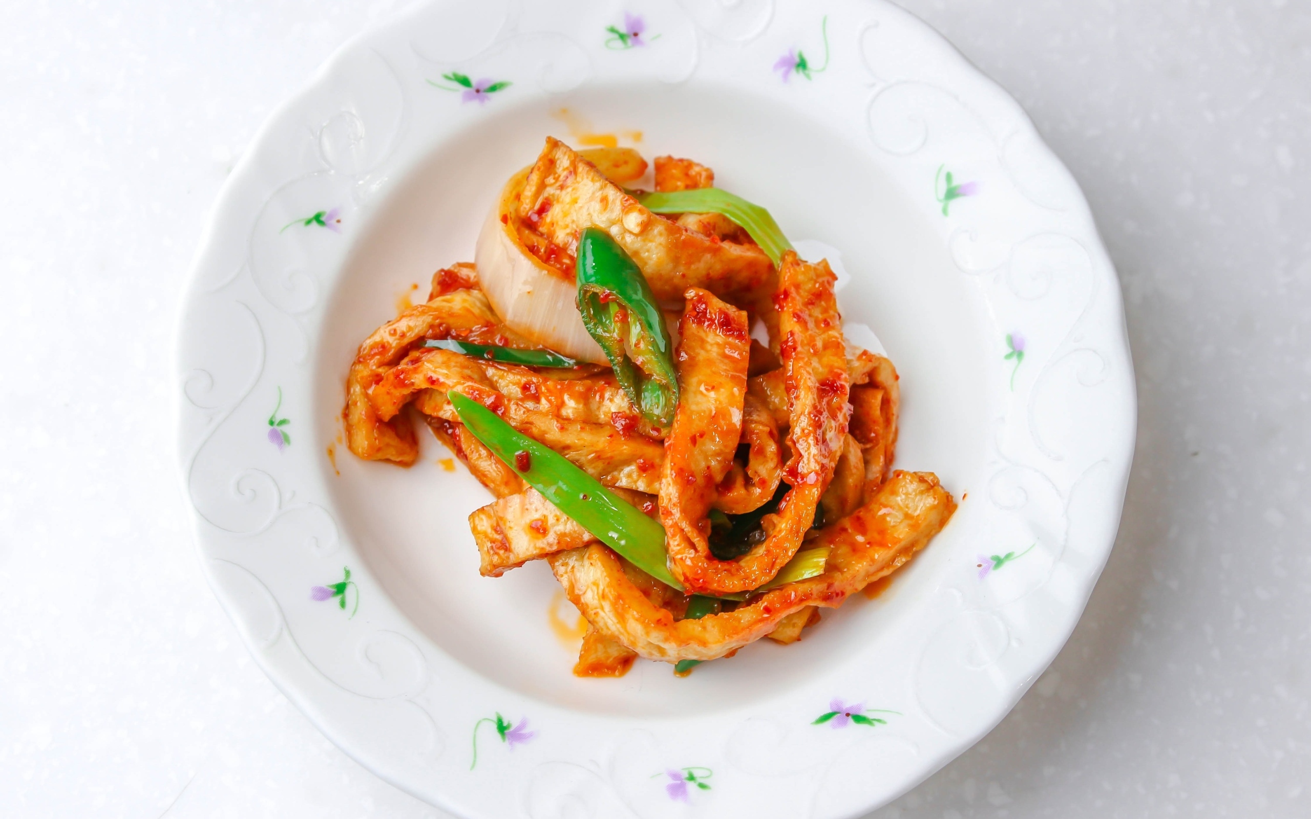 Острая рыба кусочками на тарелке