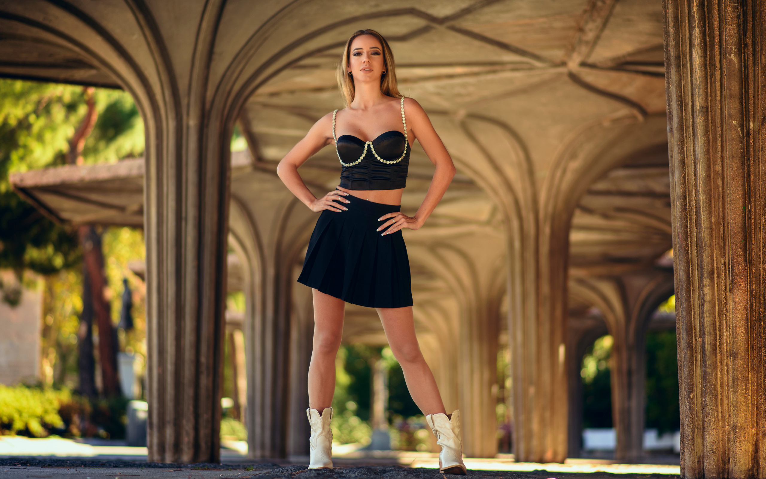 Девушка в короткой черной юбке стоит у здания