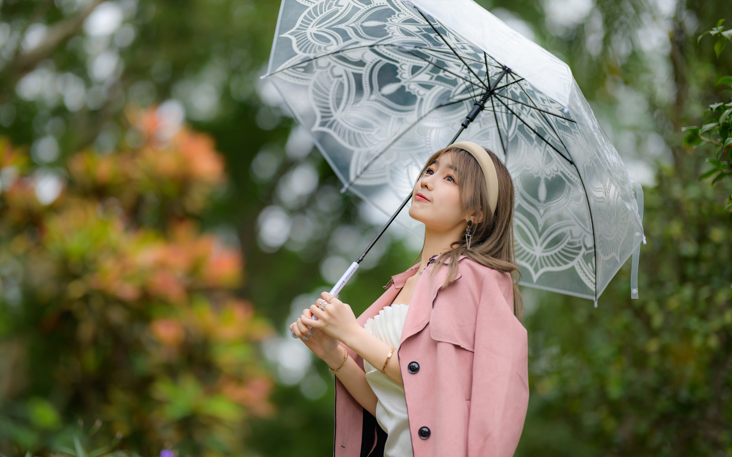 Девушка азиатка в пальто под прозрачным зонтом