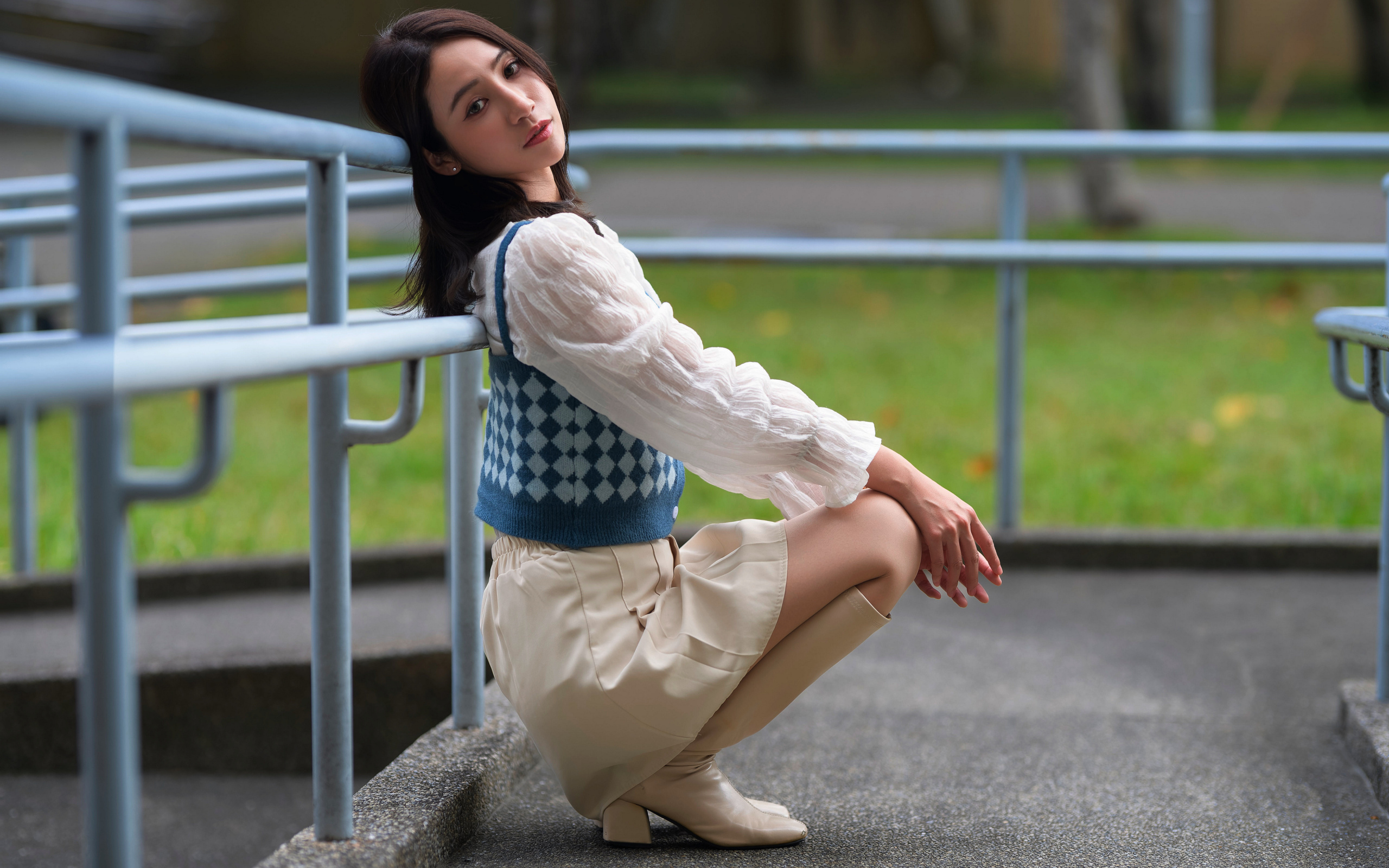 Милая девушка азиатка сидит у перил