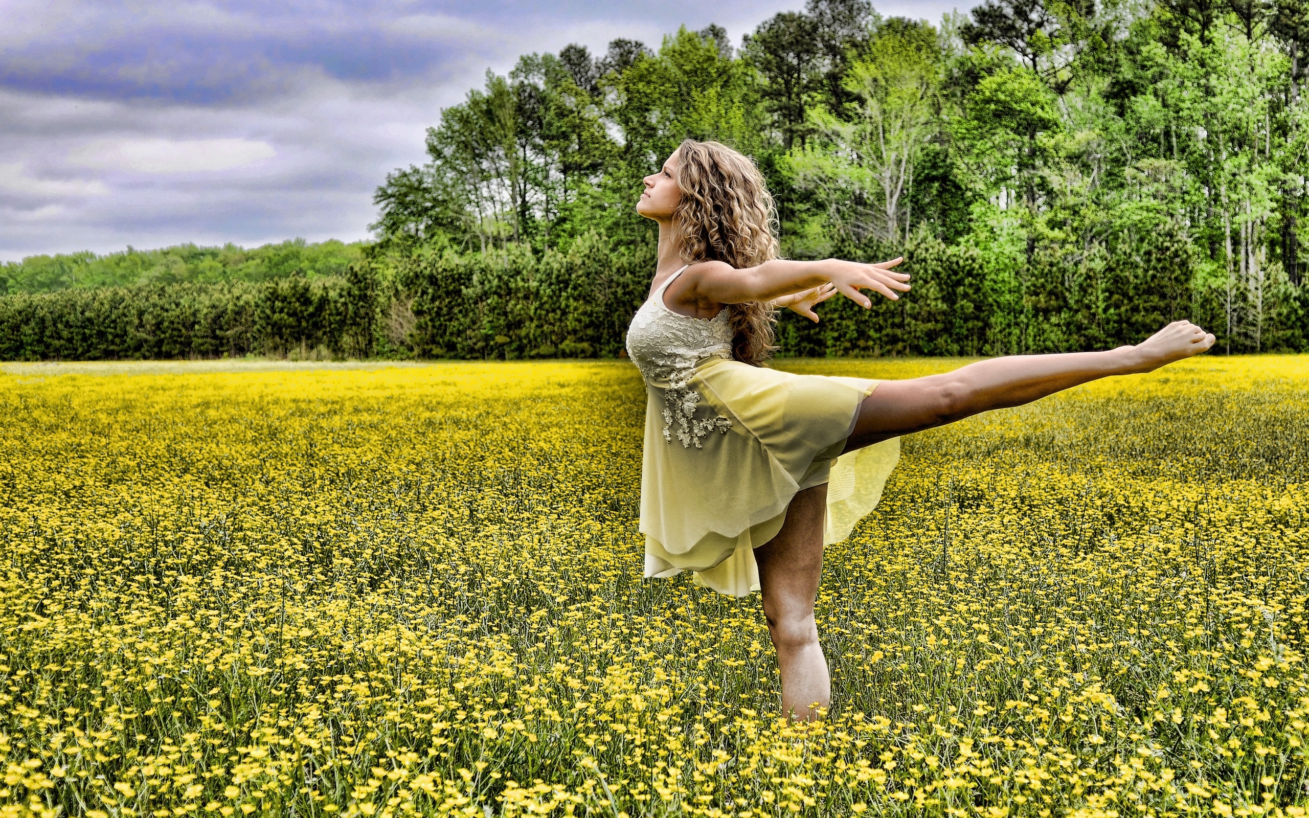 Девушка танцует на поле с желтыми цветами