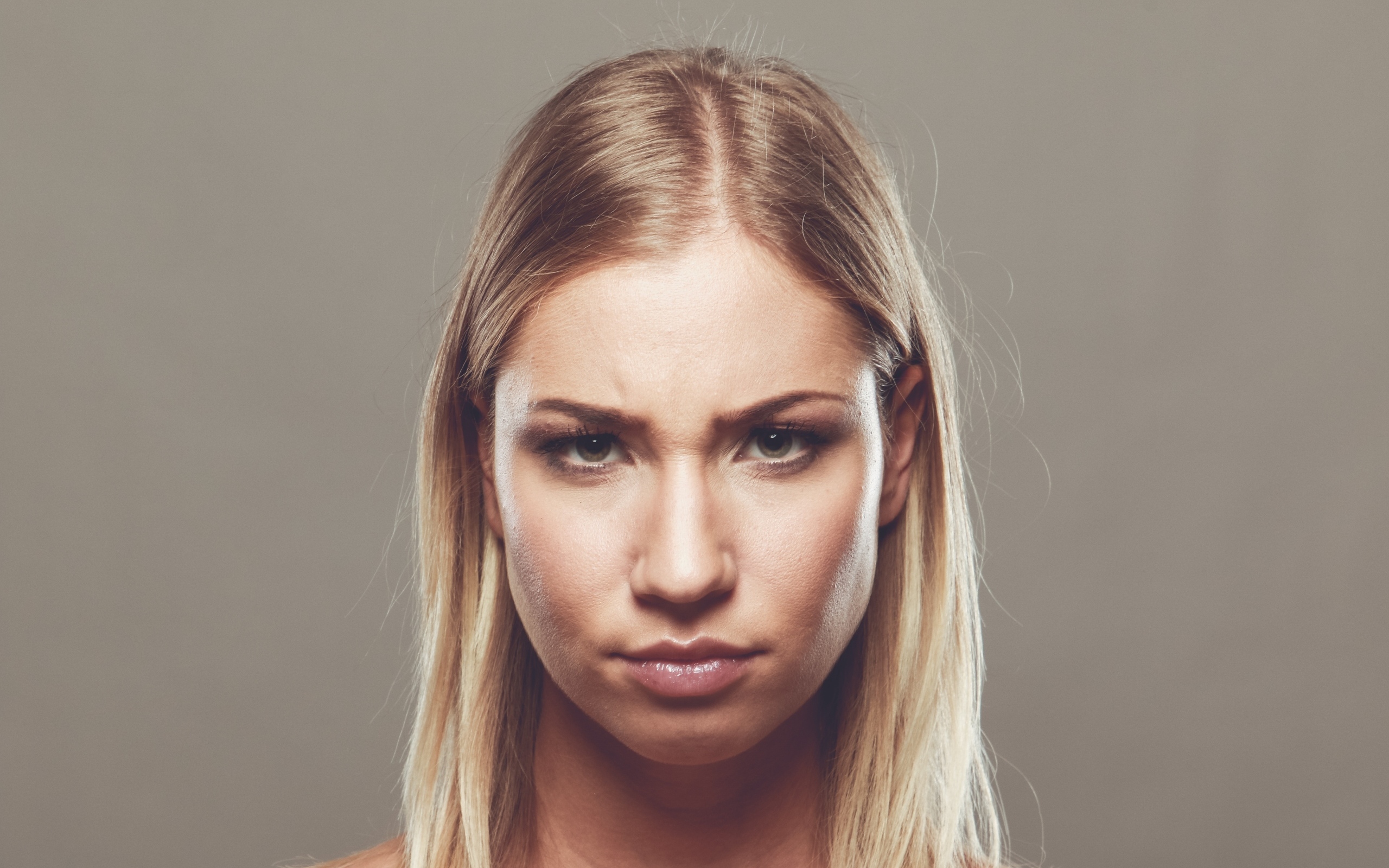 Серьезная девушка с короткой стрижкой на сером фоне