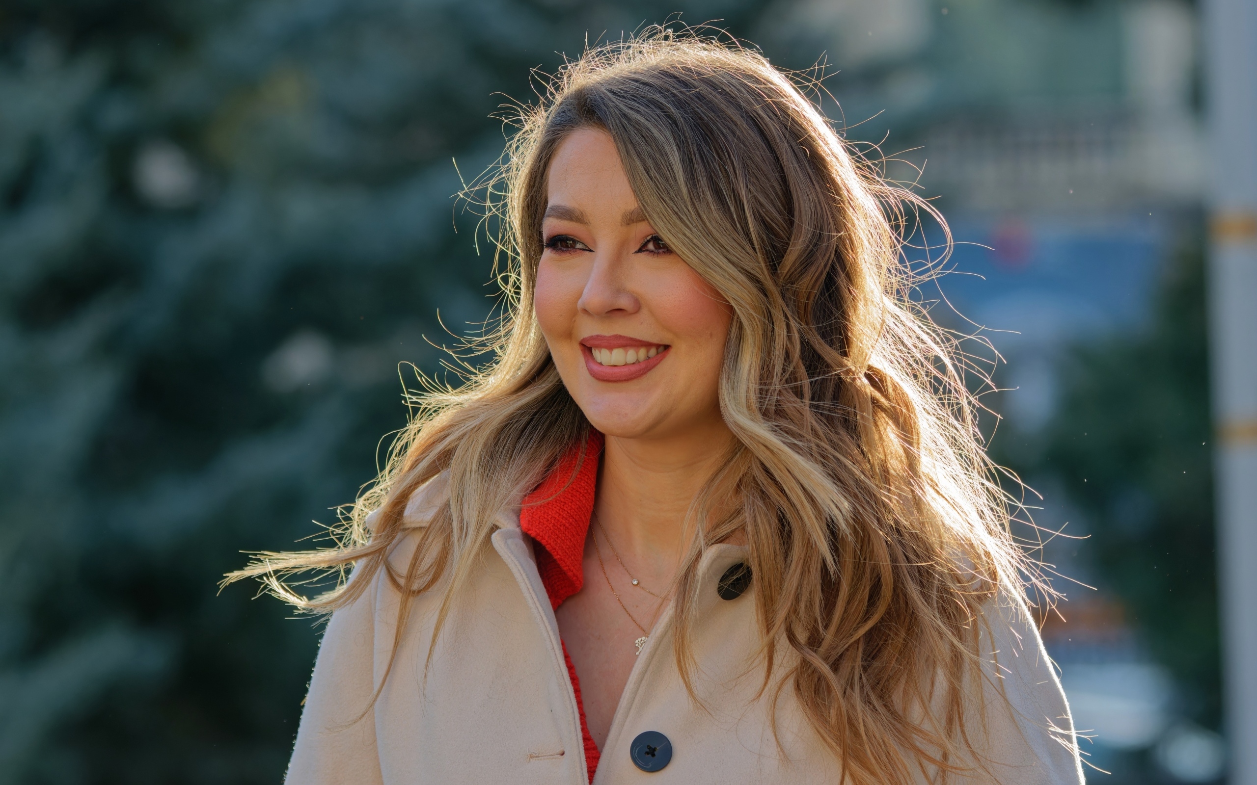 Женщина с милой улыбкой в пальто на улице