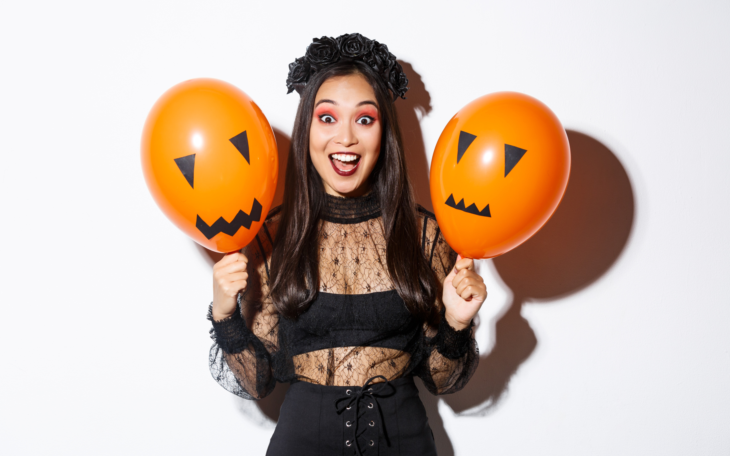 Девушка в костюме на праздник Хэллоуин с шариками в руках