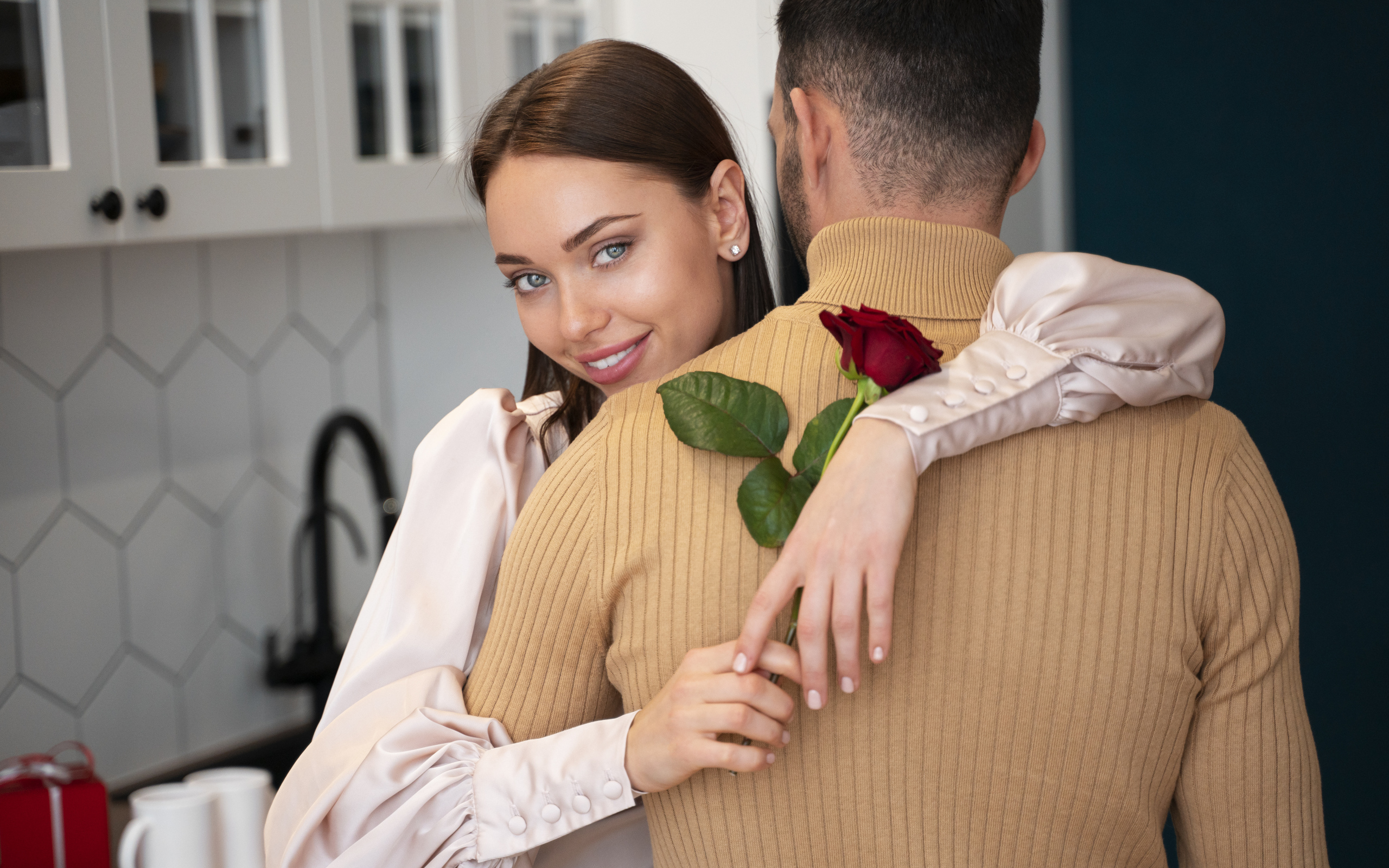 Влюбленная девушка с розой обнимает парня