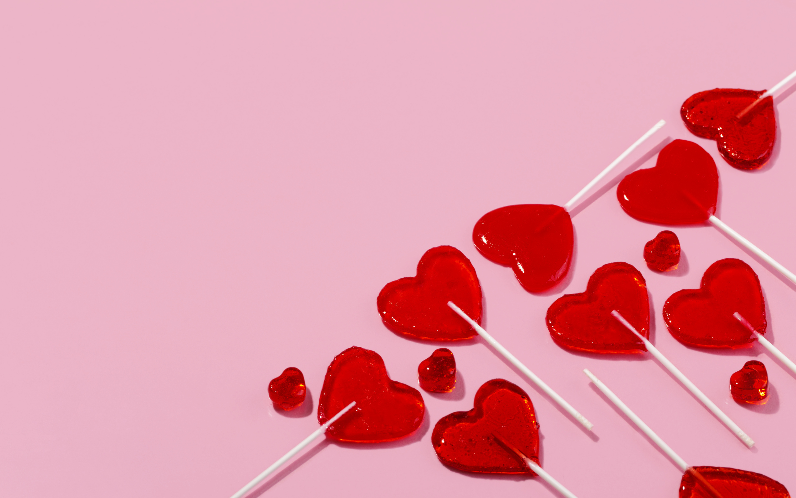 Леденцы в форме сердца на розовом фоне