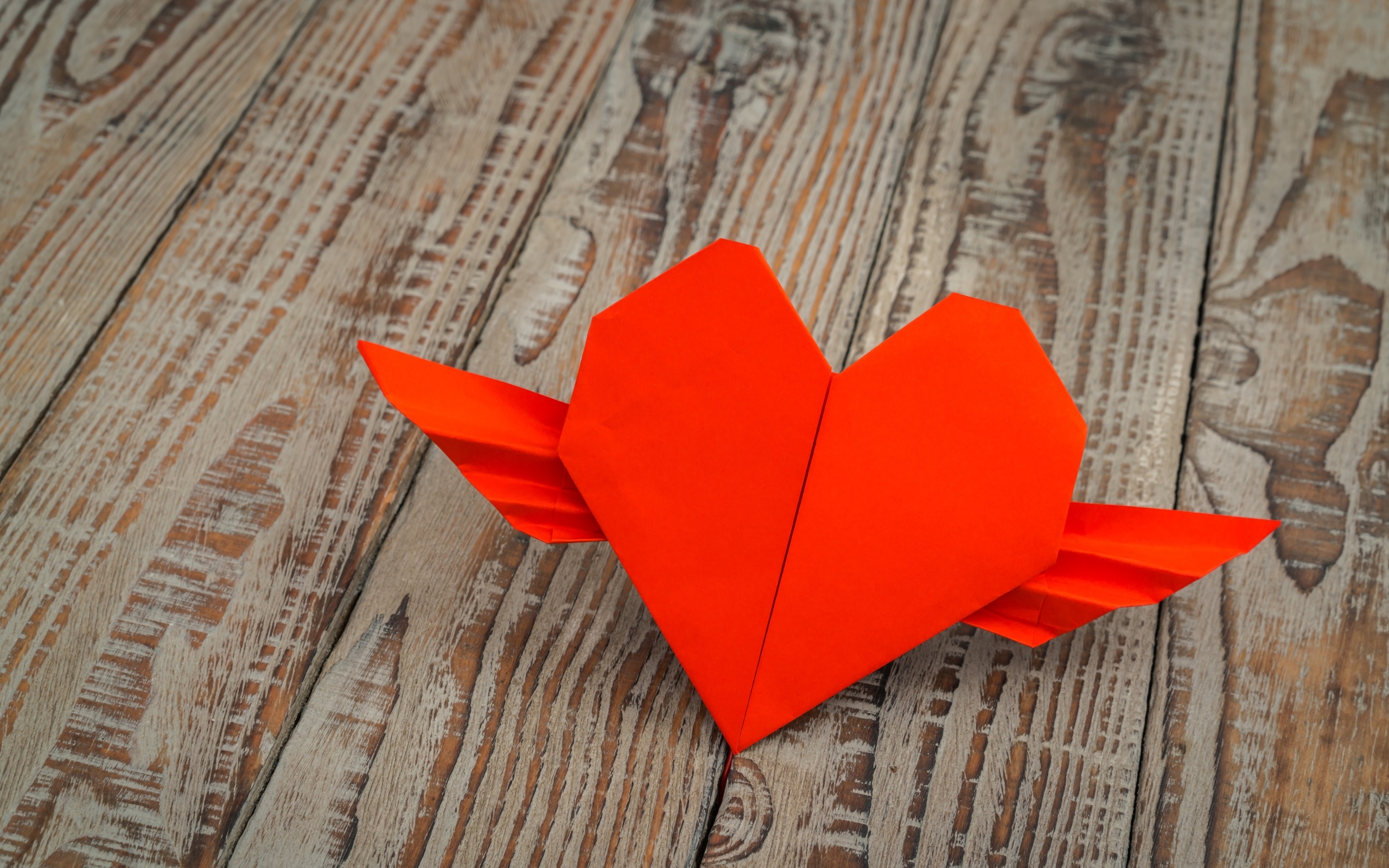 Бумажное красное сердце на деревянных досках