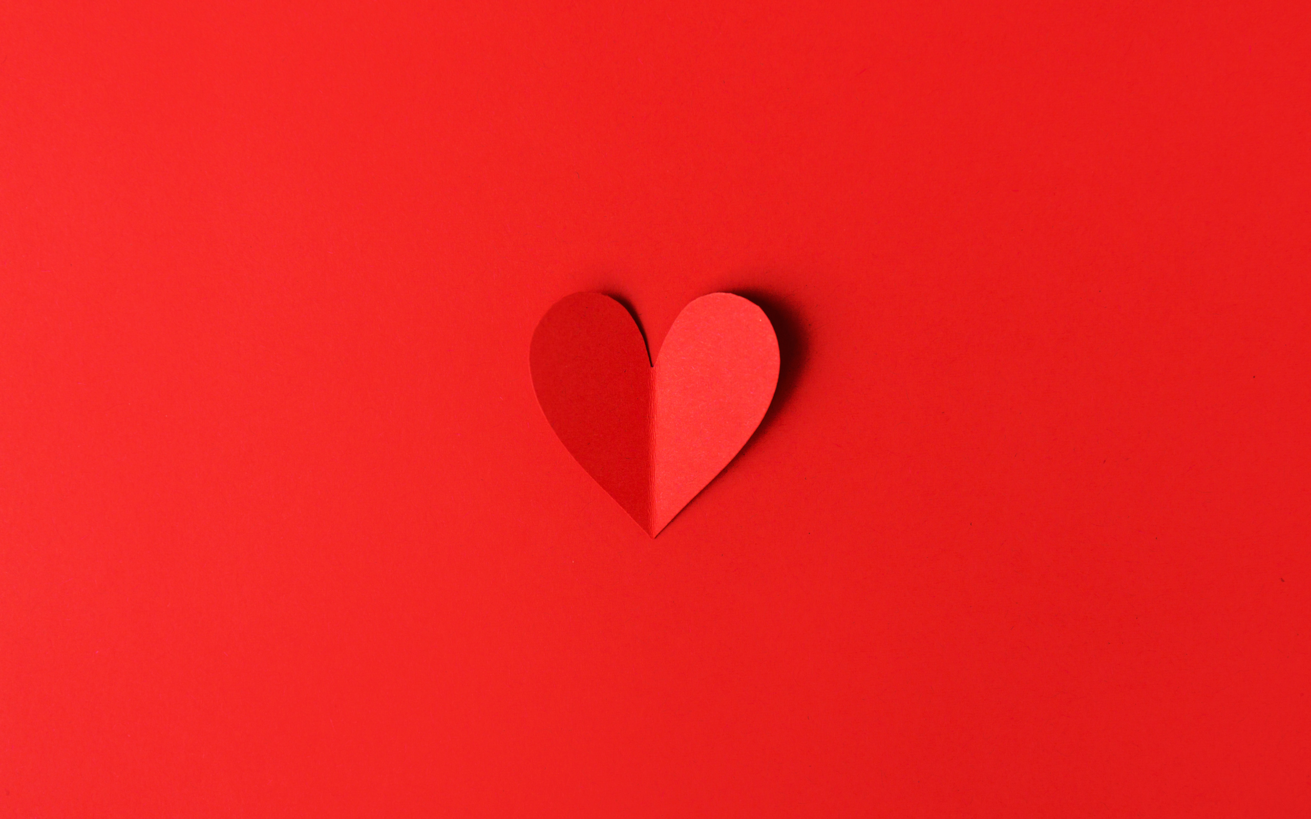 Маленькое бумажное сердце на красном фоне