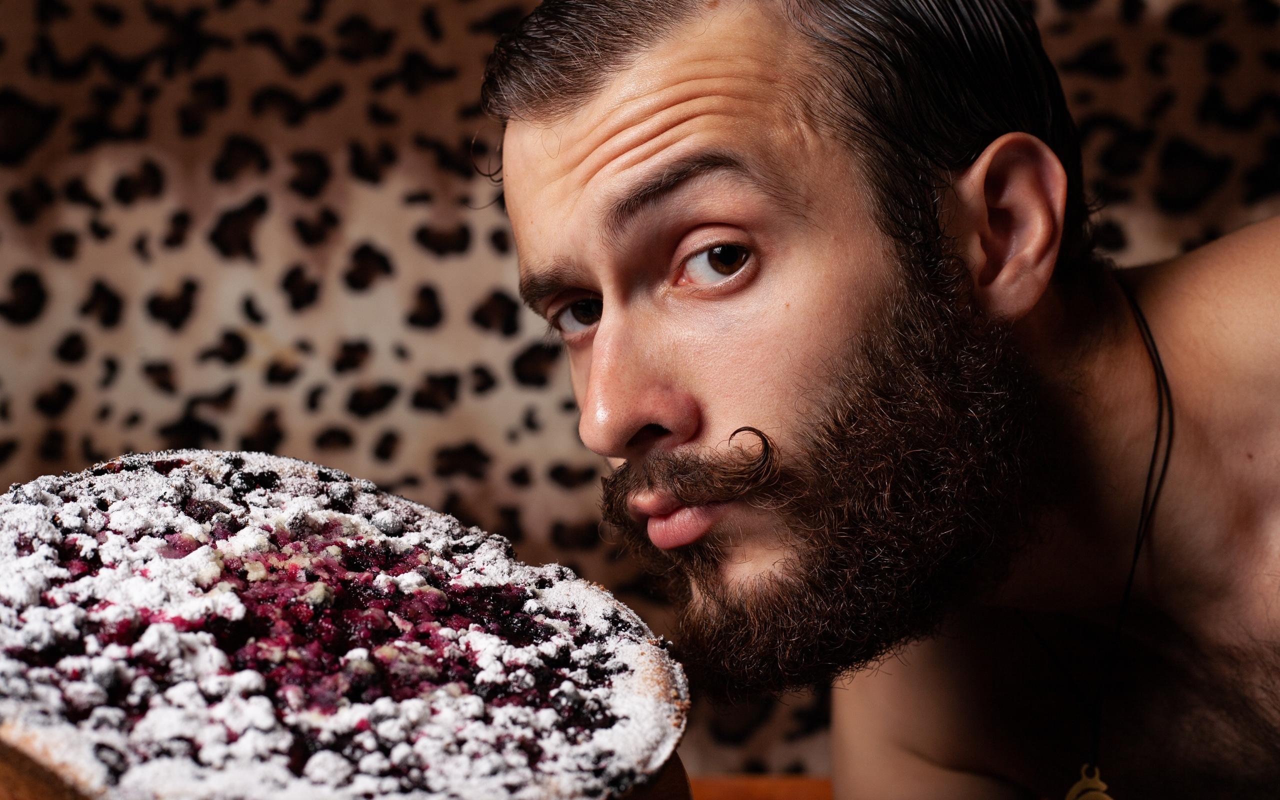 Мужчина с бородой держит сладкий пирог 