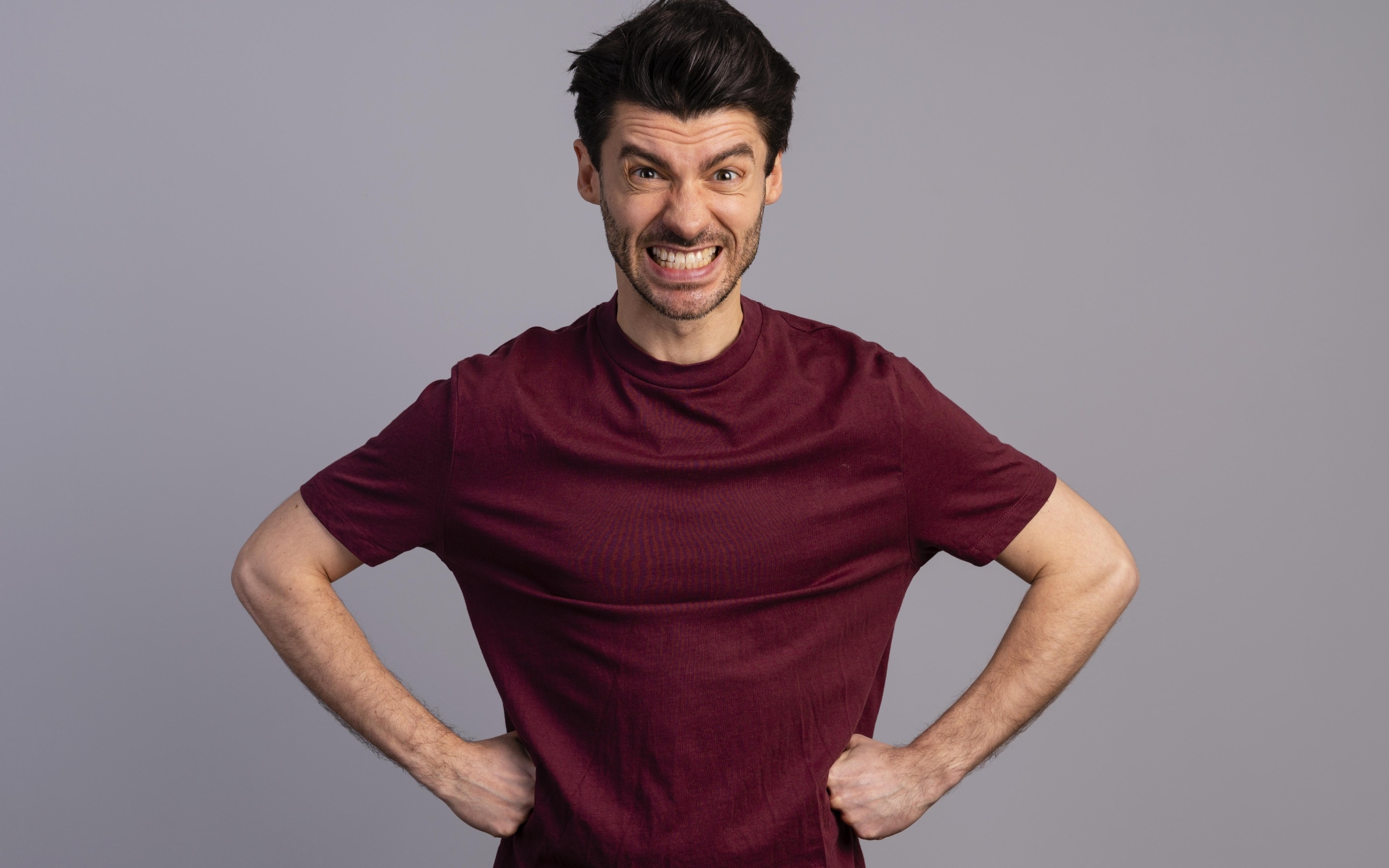 Злой мужчина на сером фоне