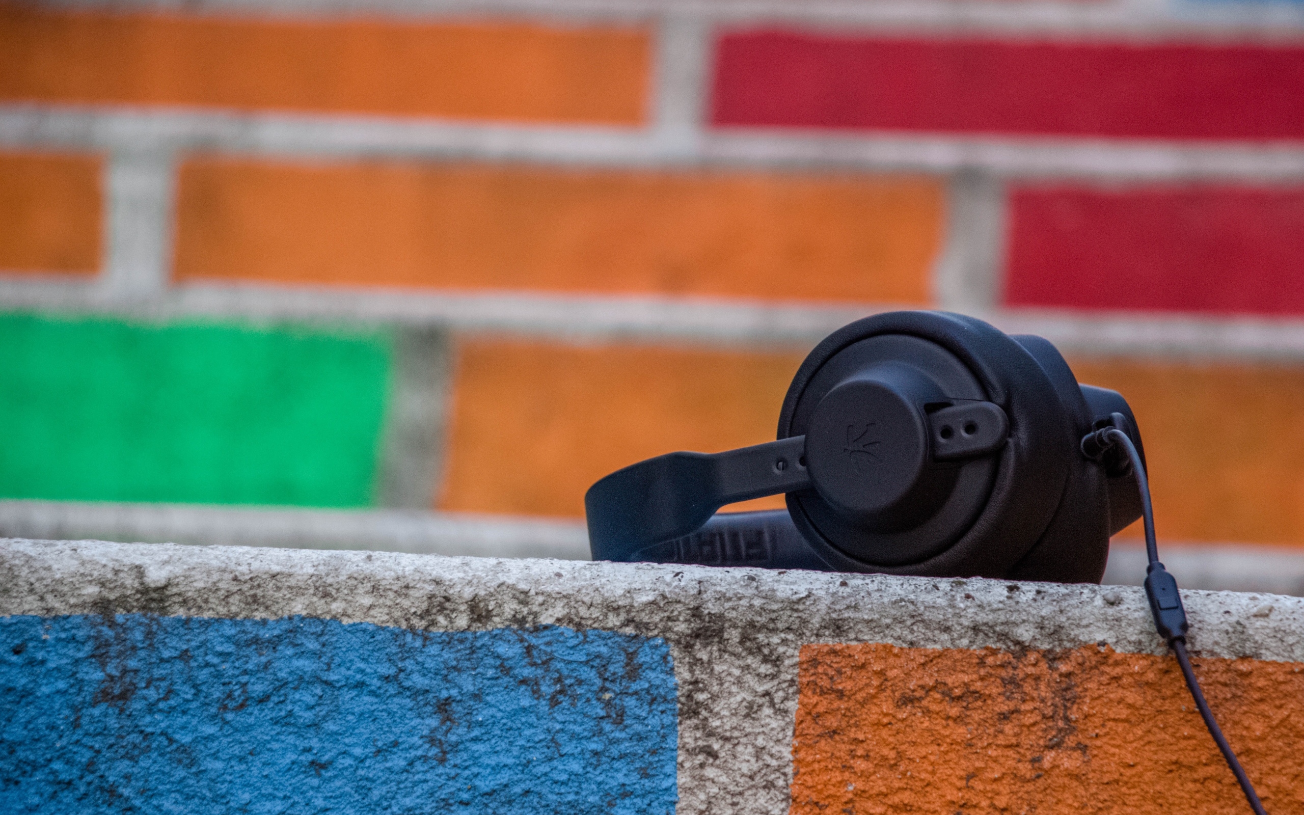 Черные наушники лежат на стене