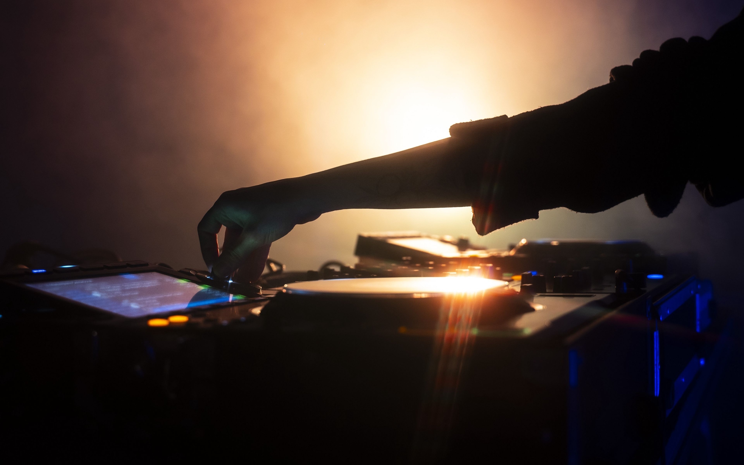 Рука диджея настраивает музыкальный пульт 