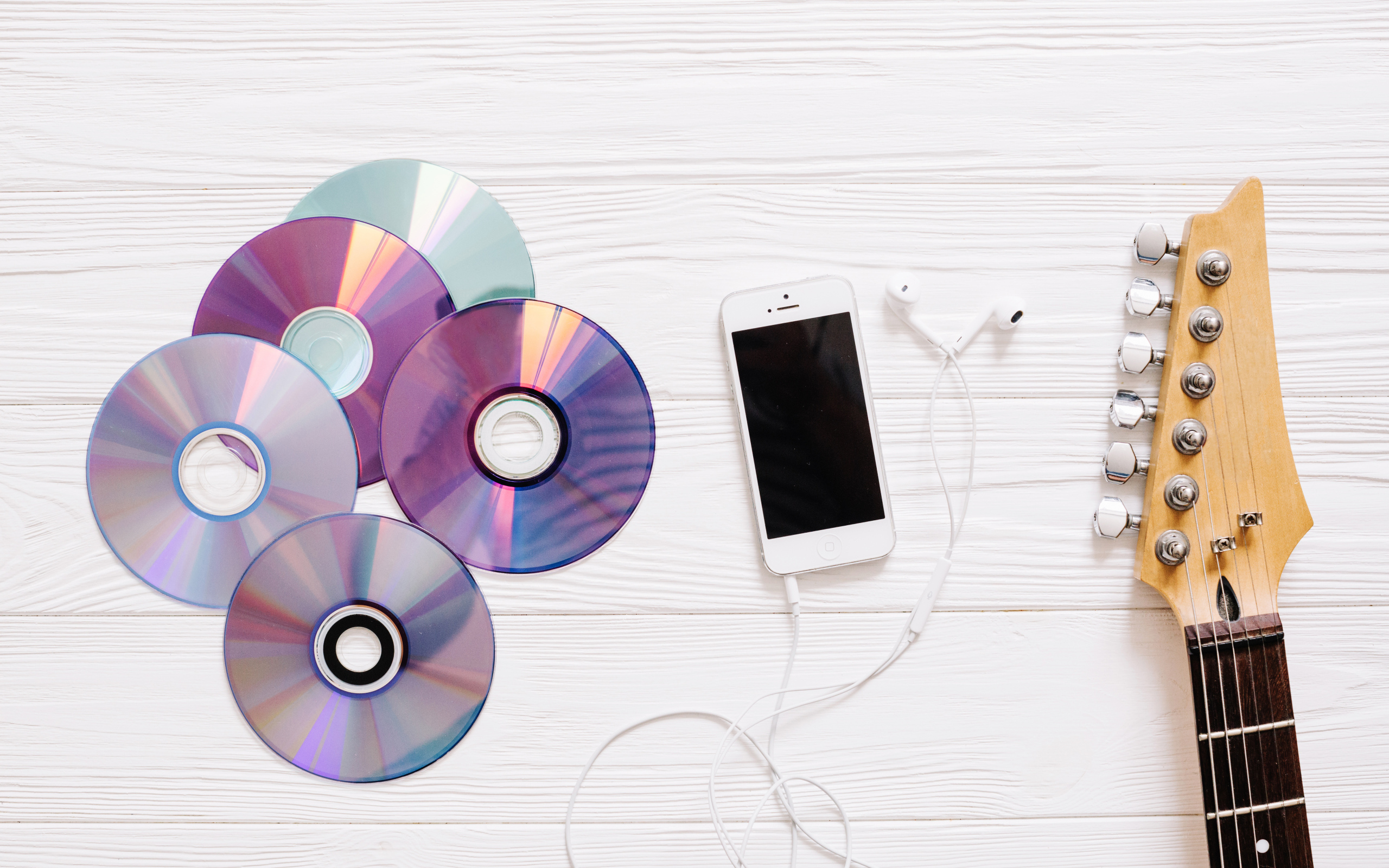 Диски с телефоном и гитарой на белом фоне
