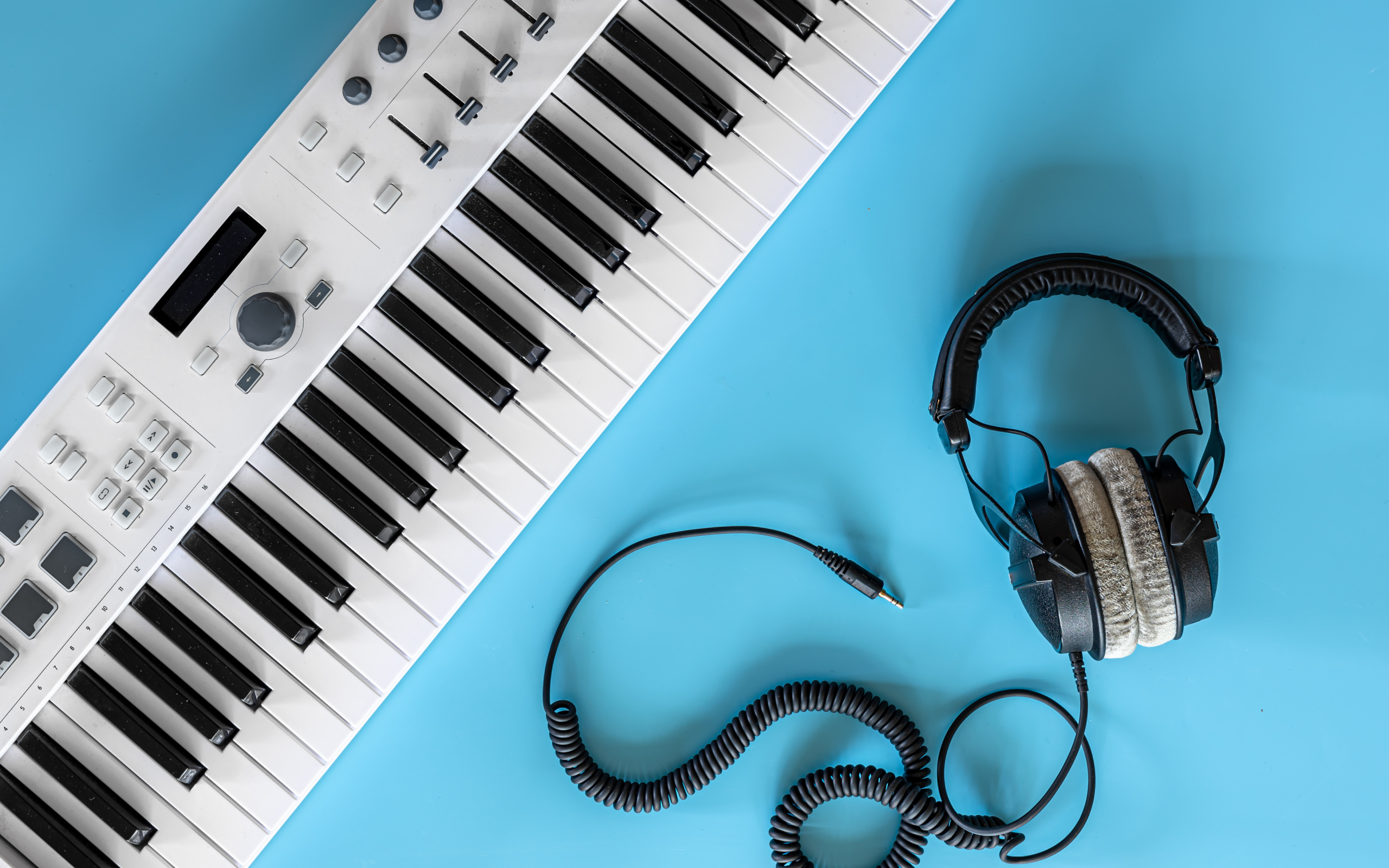 Наушники на голубом фоне с синтезатором