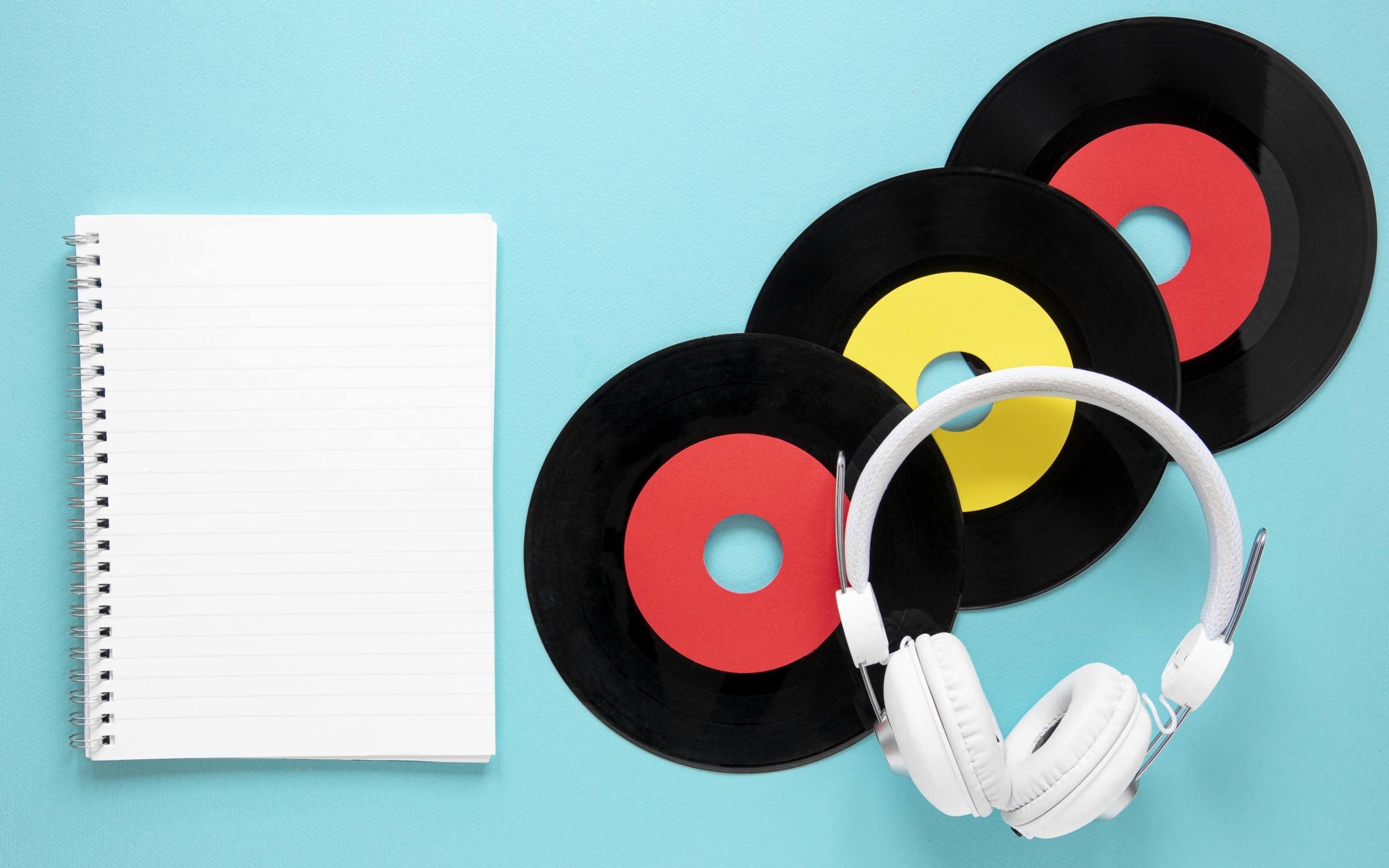 Пластинки на голубом фоне с блокнотом и наушниками