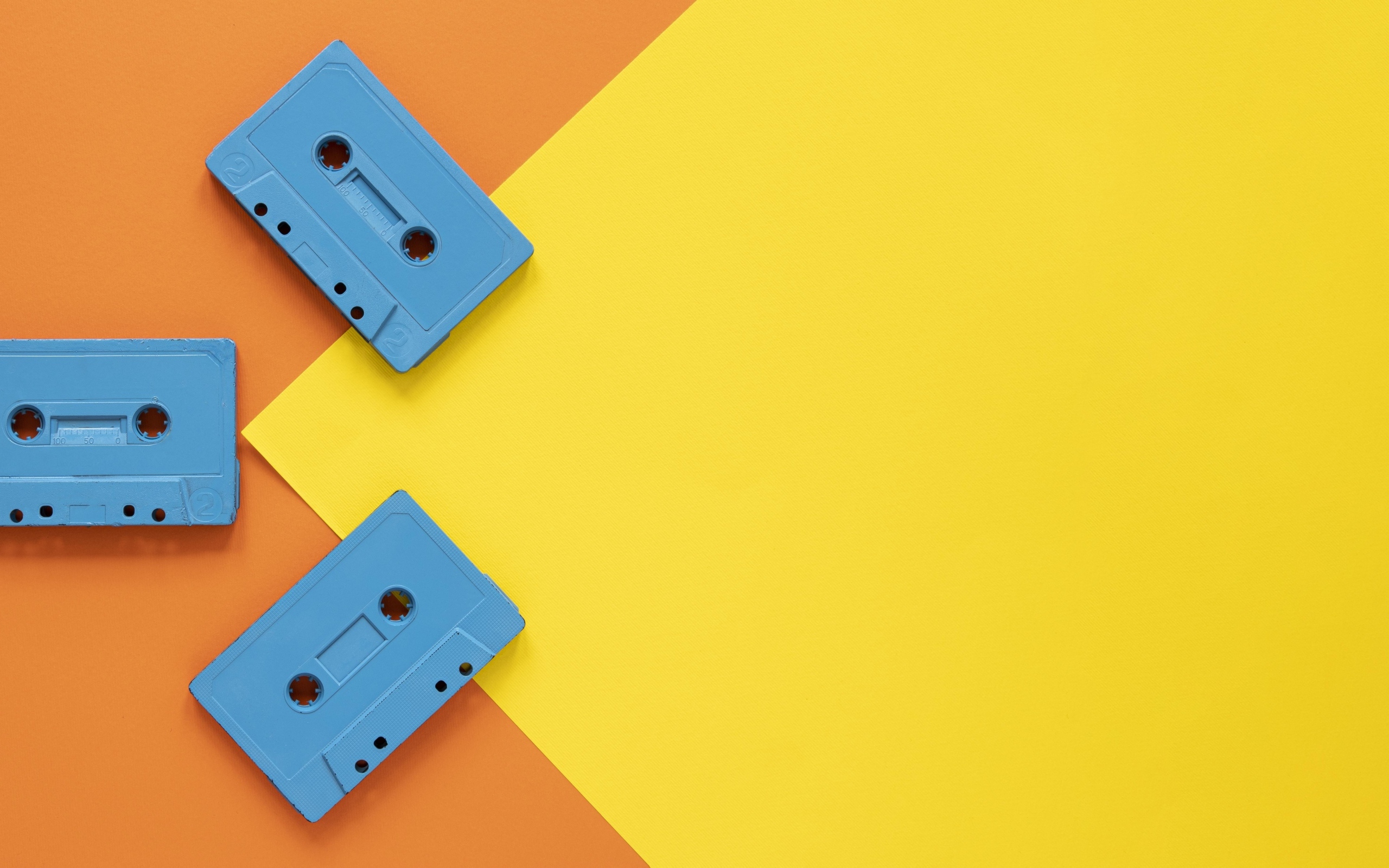 Три голубые кассеты на желто-оранжевом фоне