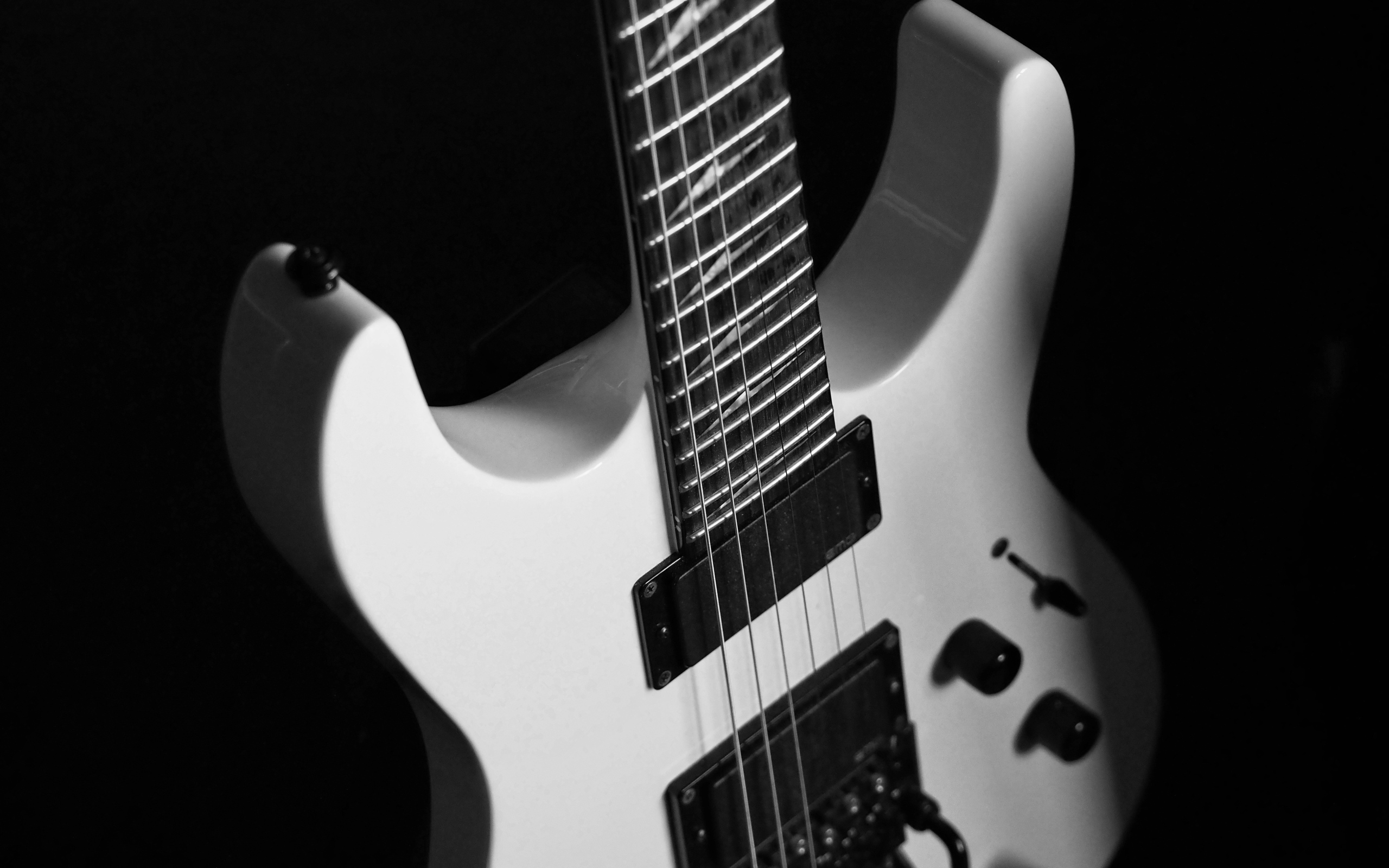 Белая электрогитара на черном фоне
