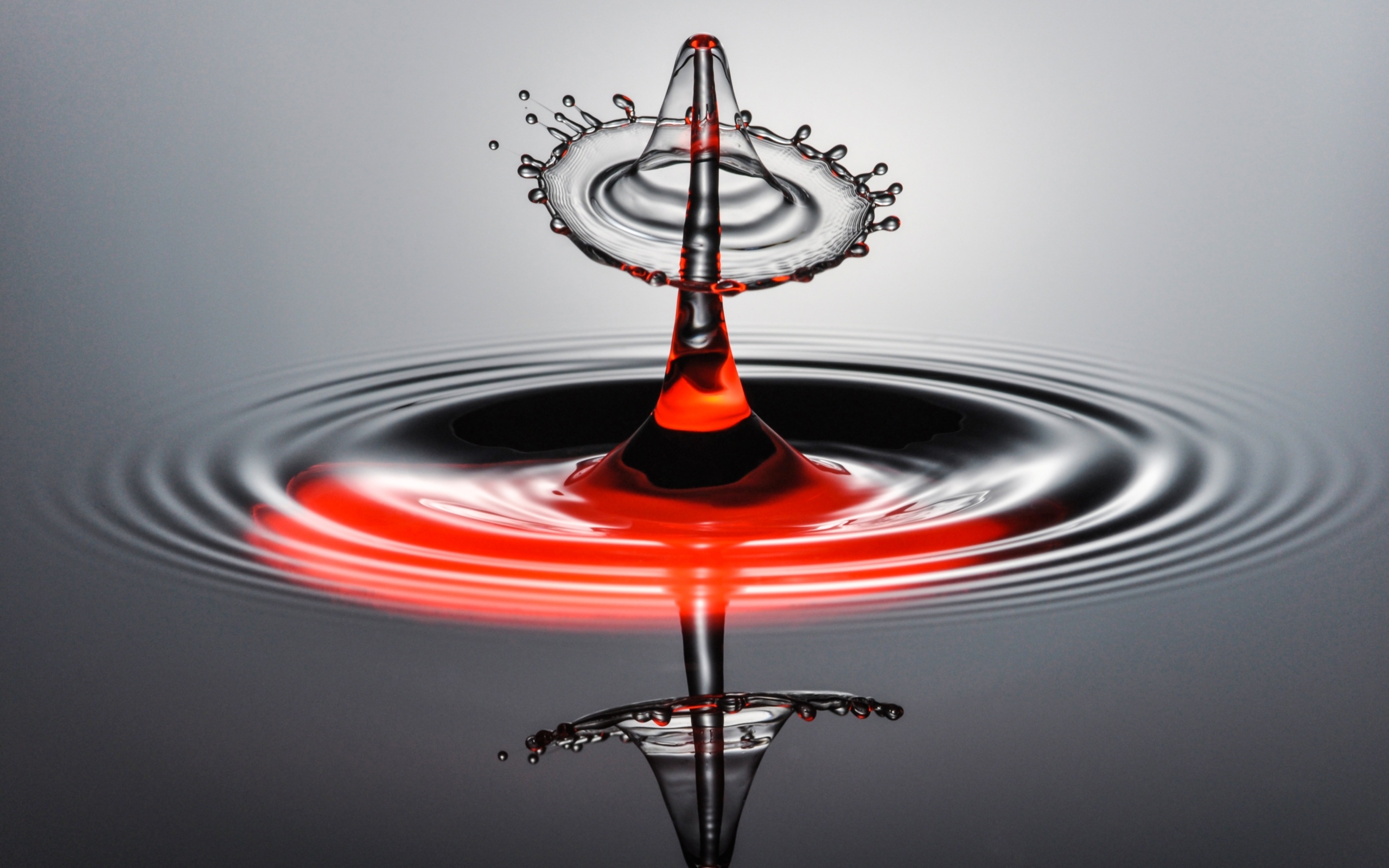 Брызги от капли воды на серой поверхности