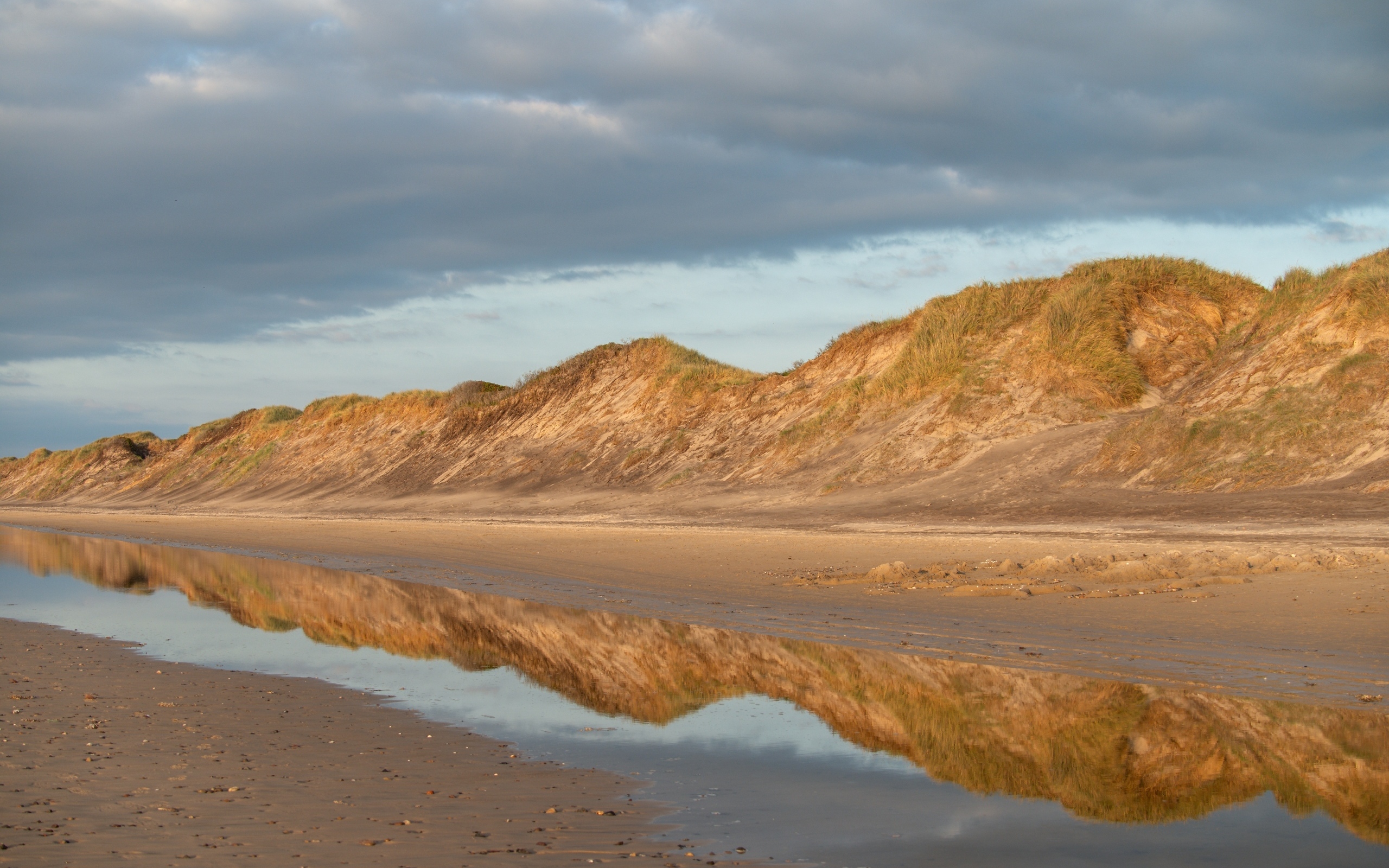 Холты отражаются в реке под грозовым небом