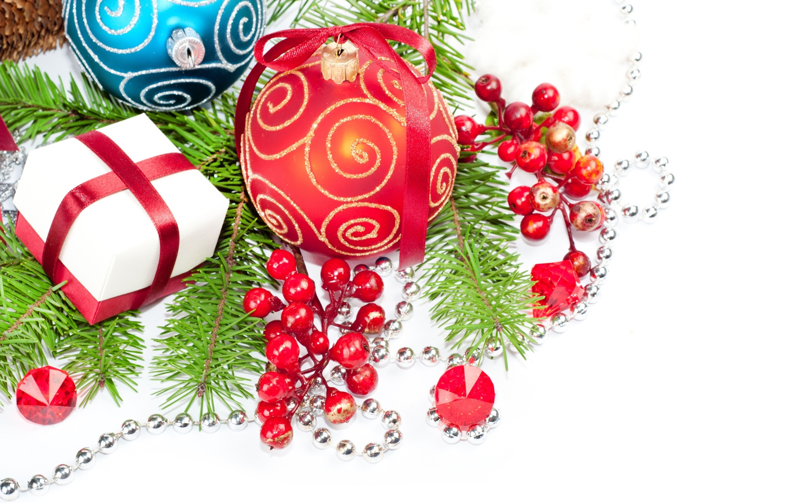 Разноцветные елочные игрушки с ветками на белом фоне