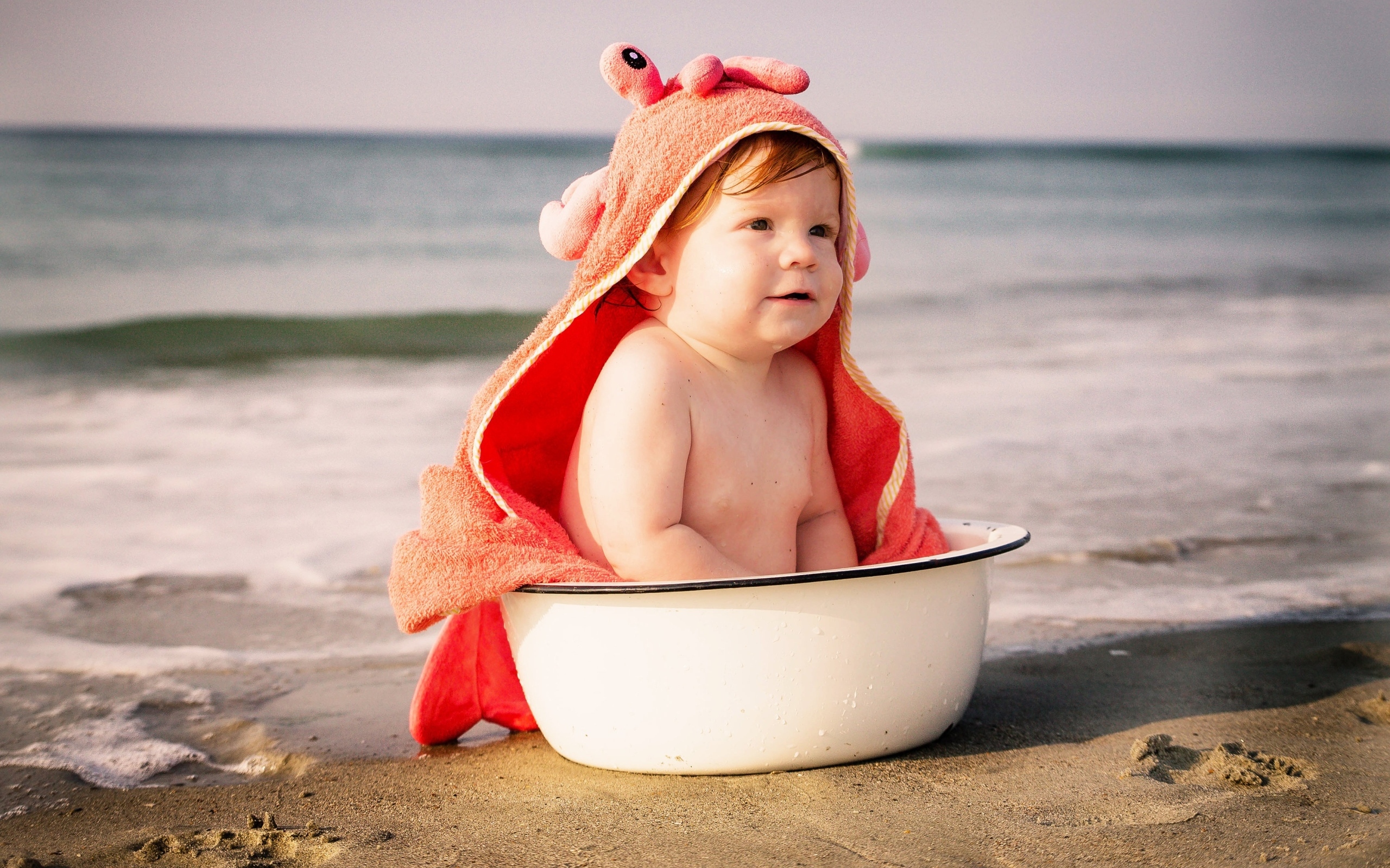 Ребенок в миске на берегу моря