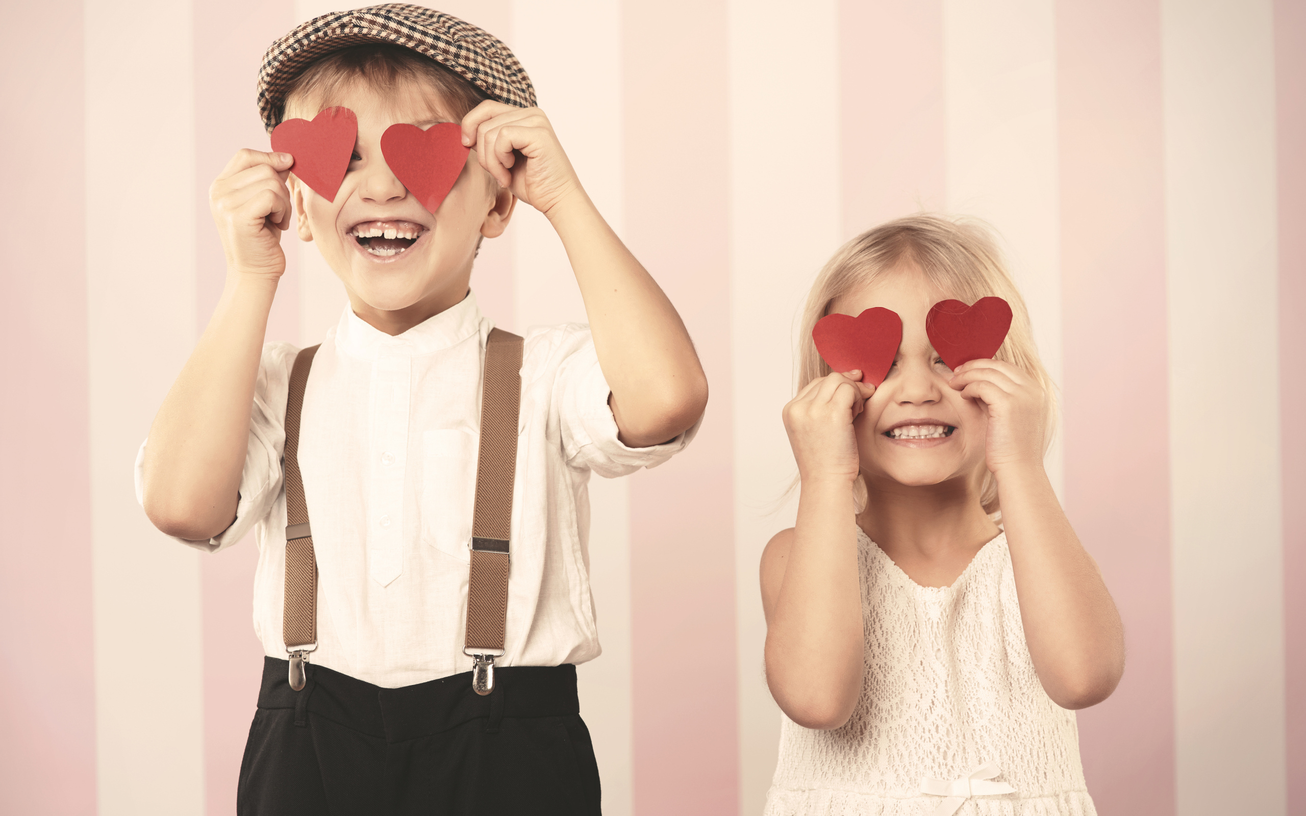 Мальчик и девочка с сердечками в руках