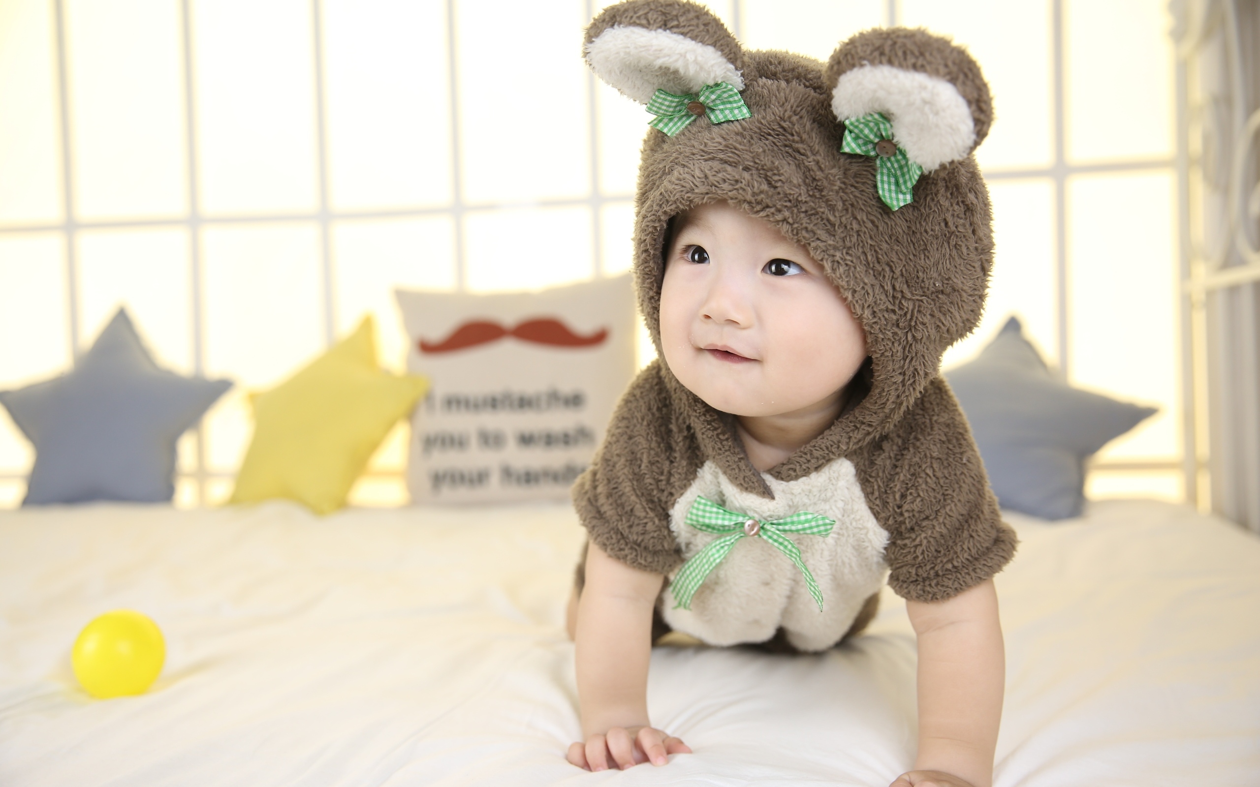 Ребенок в костюме медвежонка на кровати